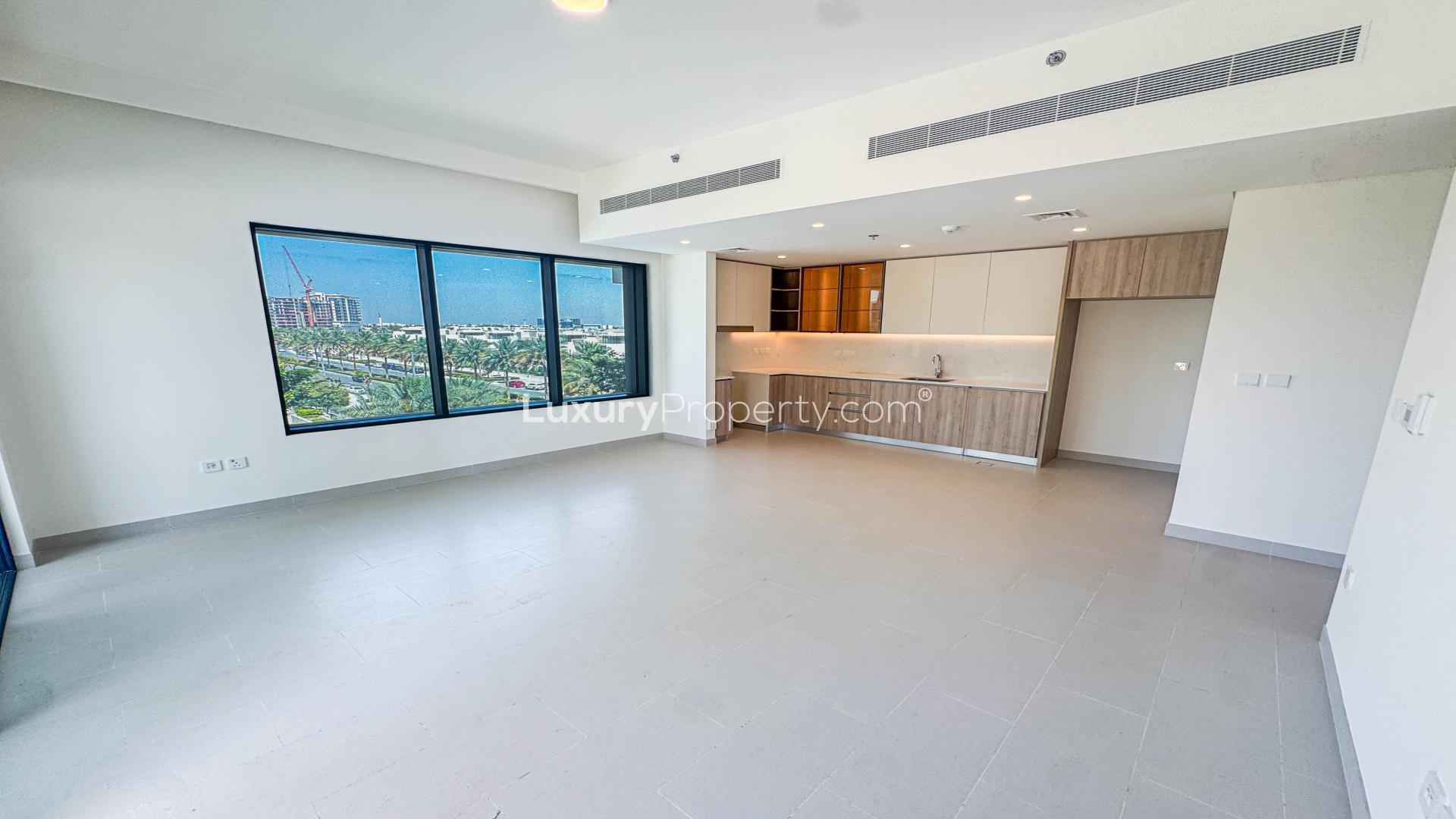 "Spacious corner apartment in Dubai Hill Estate with pool and amenities view for rent.",Empty apartment interior with kitchen and pool view in Dubai Hill Estate, Park Field Tower 1