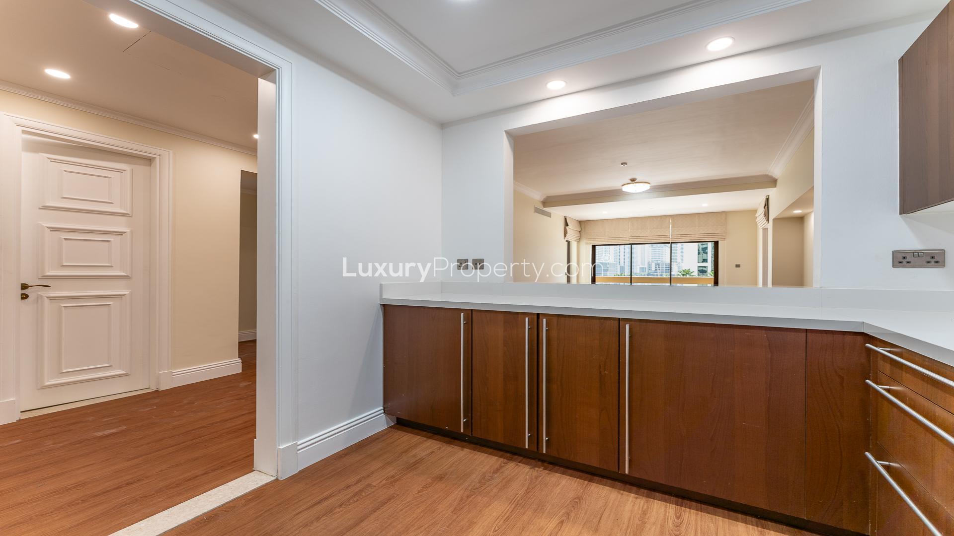 Modern kitchen in Palm Jumeirah apartment for rent, featuring wood cabinetry and stainless appliances