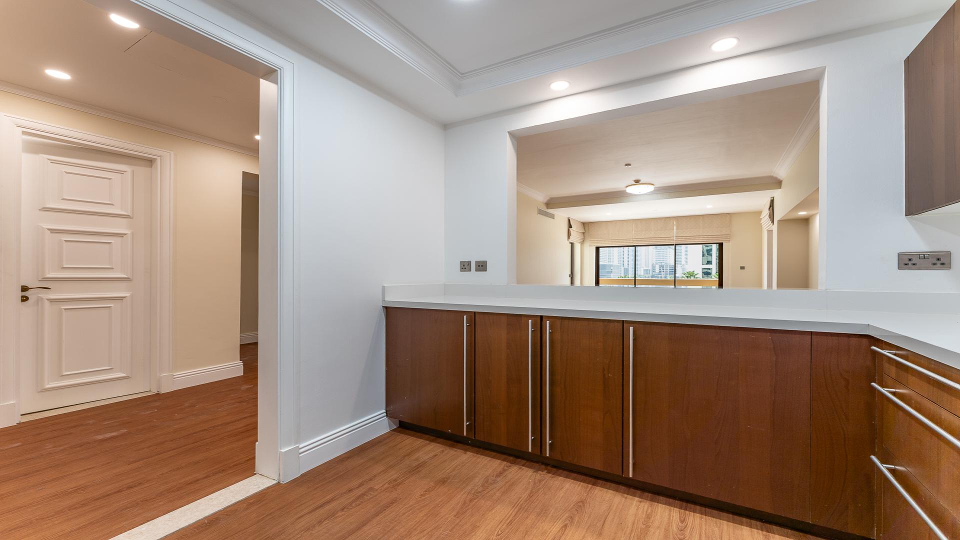 Modern kitchen in Palm Jumeirah apartment for rent, featuring wood cabinetry and stainless appliances