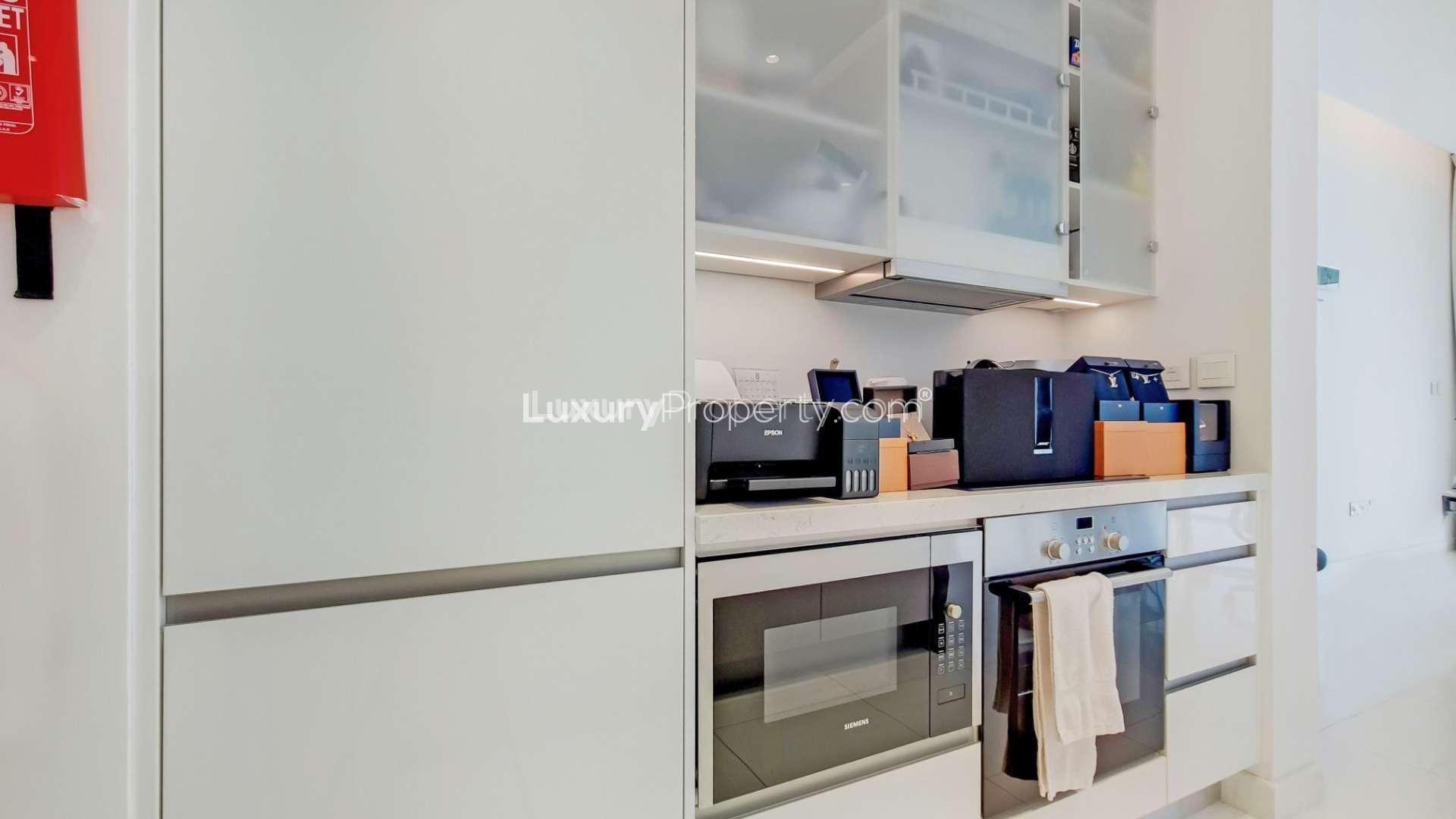 Modern kitchen in 2-bedroom Jumeirah Beach Residence apartment, featuring sleek appliances and storage