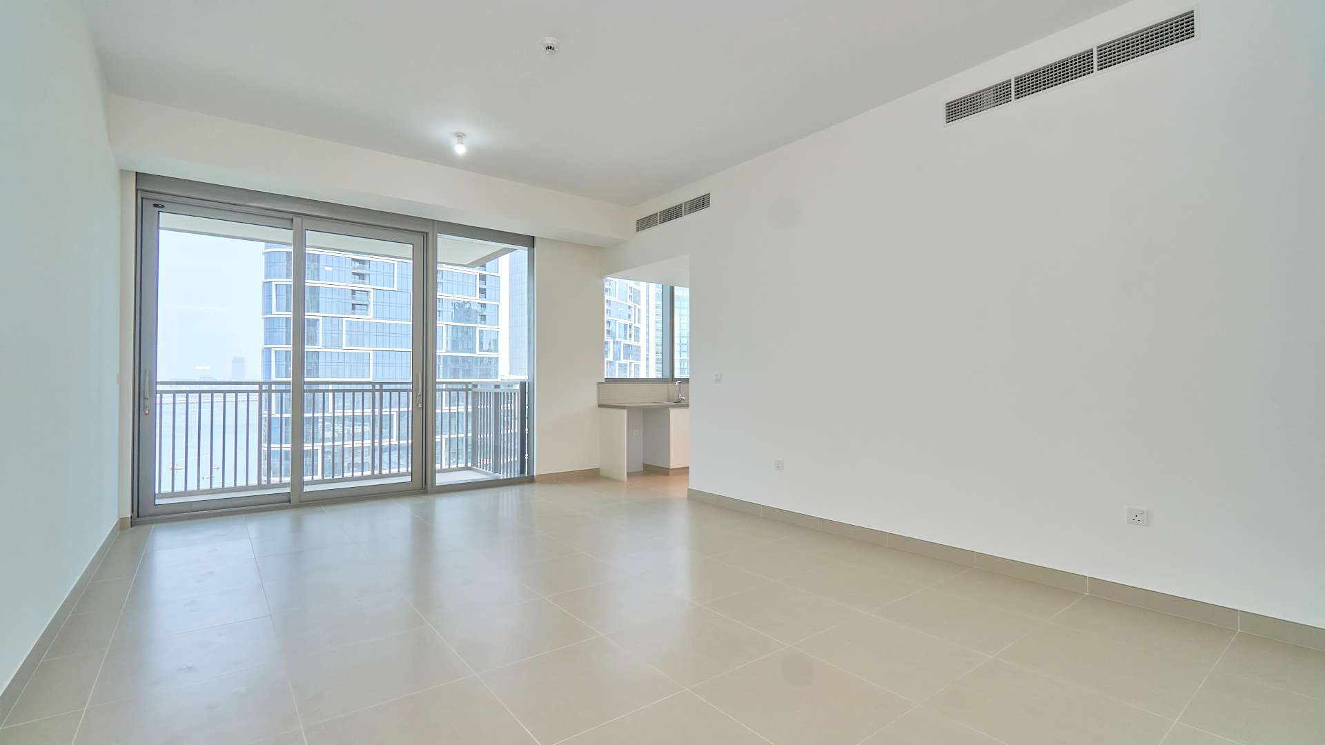Empty living room with large windows in 2-bedroom Dubai Marina waterfront apartment for rent