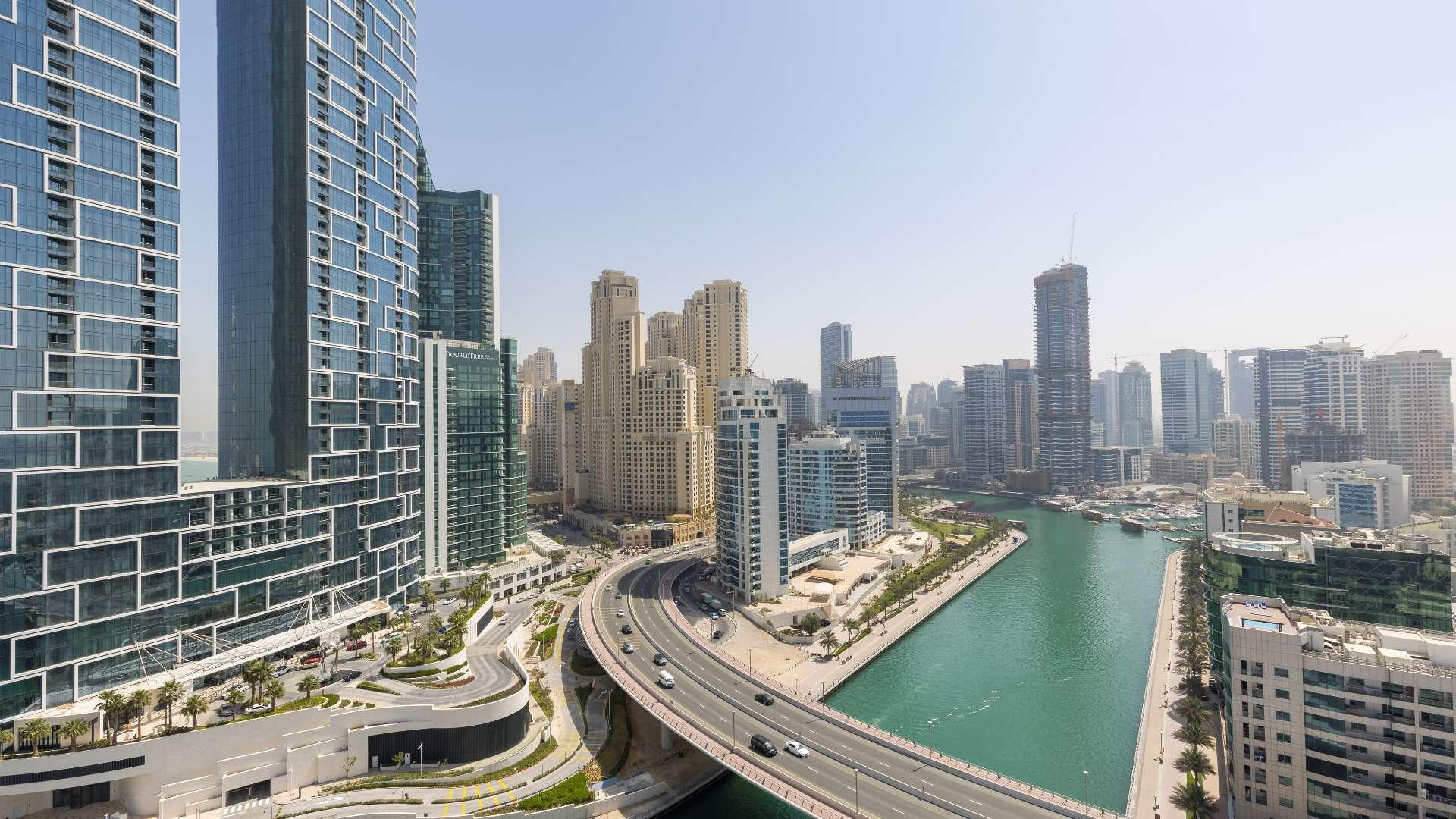 Bright living room with large windows and city view in Dubai Marina apartment for rent