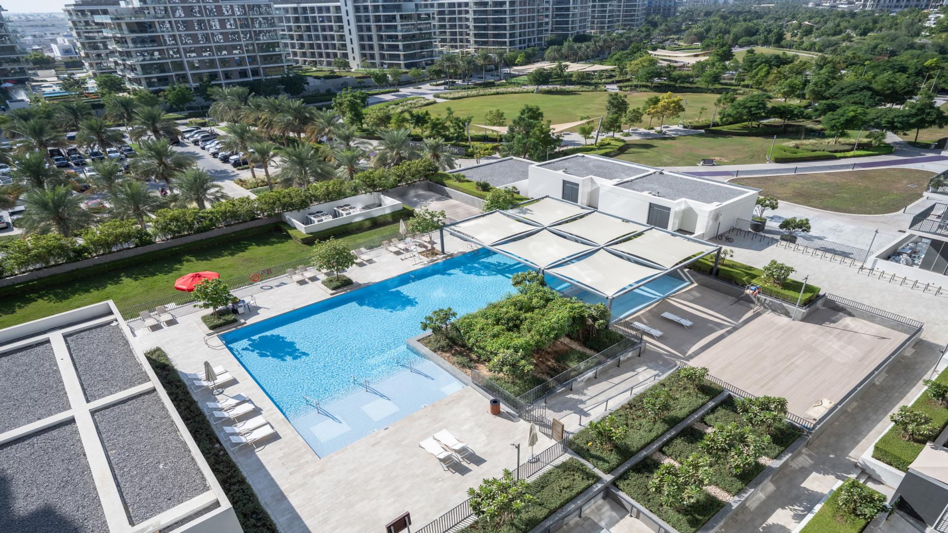 Balcony view from 2-bedroom apartment in Park Ridge Dubai Hills, overlooking pool and gardens