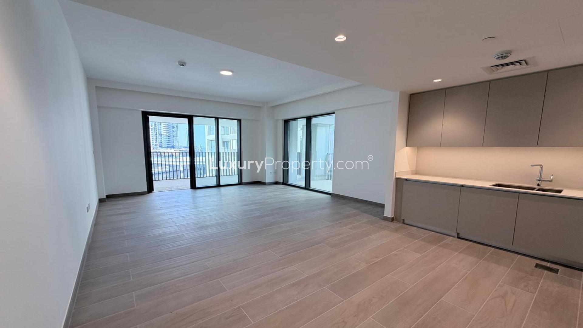 "Spacious living area in 2-bedroom apartment, Grove at Creek Beach, Dubai Creek Harbour.",Modern open-plan kitchen and living area in Dubai Creek Harbour apartment for rent