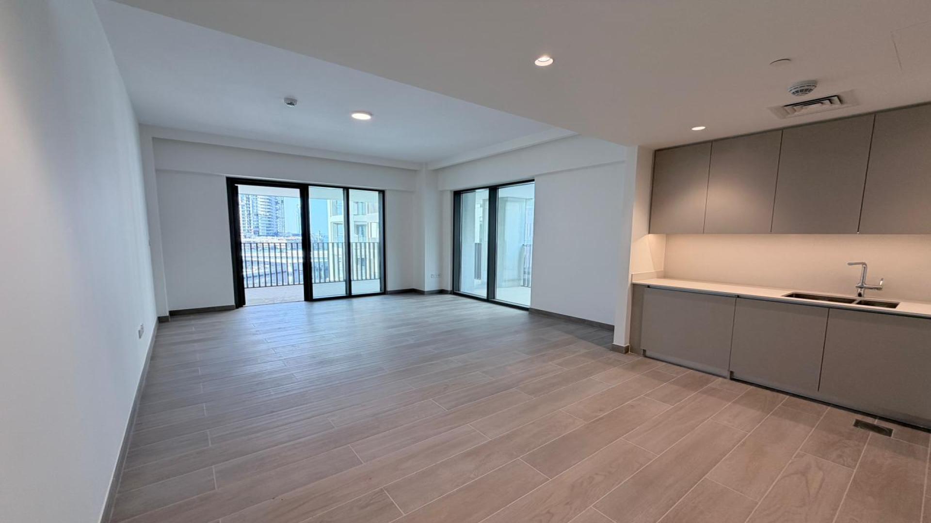 "Spacious living area in 2-bedroom apartment, Grove at Creek Beach, Dubai Creek Harbour.",Modern open-plan kitchen and living area in Dubai Creek Harbour apartment for rent