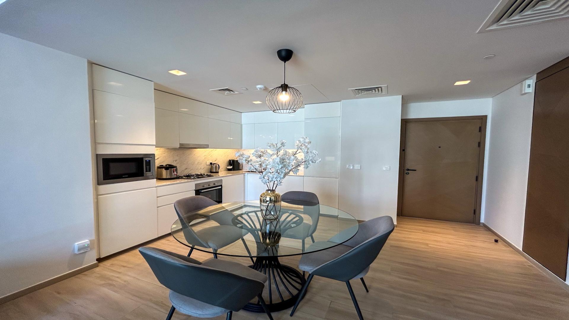 Fully furnished living room in Dubai Creek Harbour apartment with balcony view