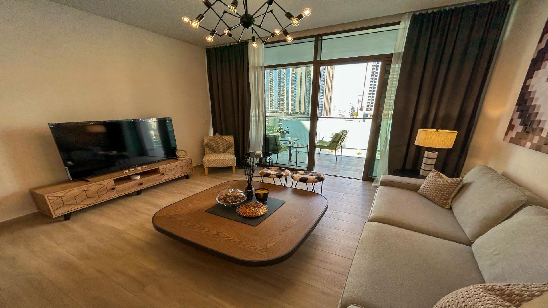 Fully furnished living room in Dubai Creek Harbour apartment, modern decor, balcony view