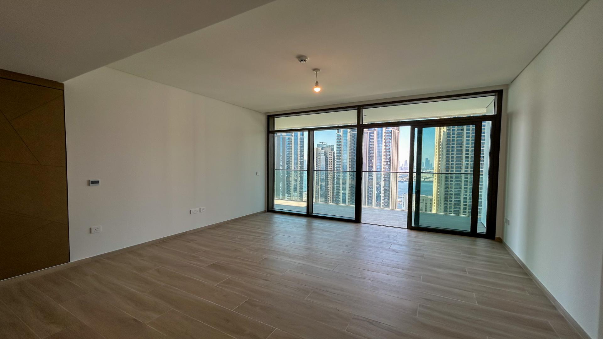 Empty living room with city skyline views in Dubai Creek Harbour apartment