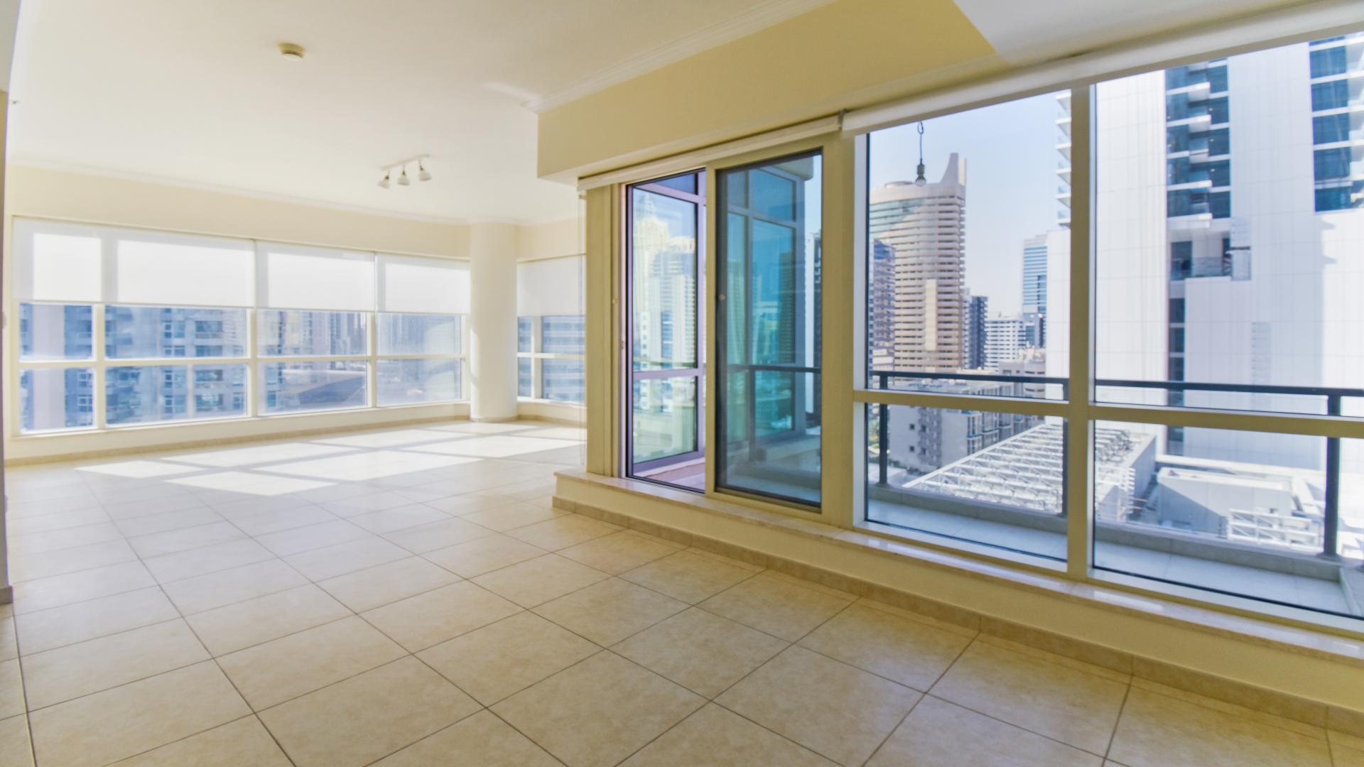 Luxury Dubai Marina apartment with large windows, tiled floors, and city views in Al Majara