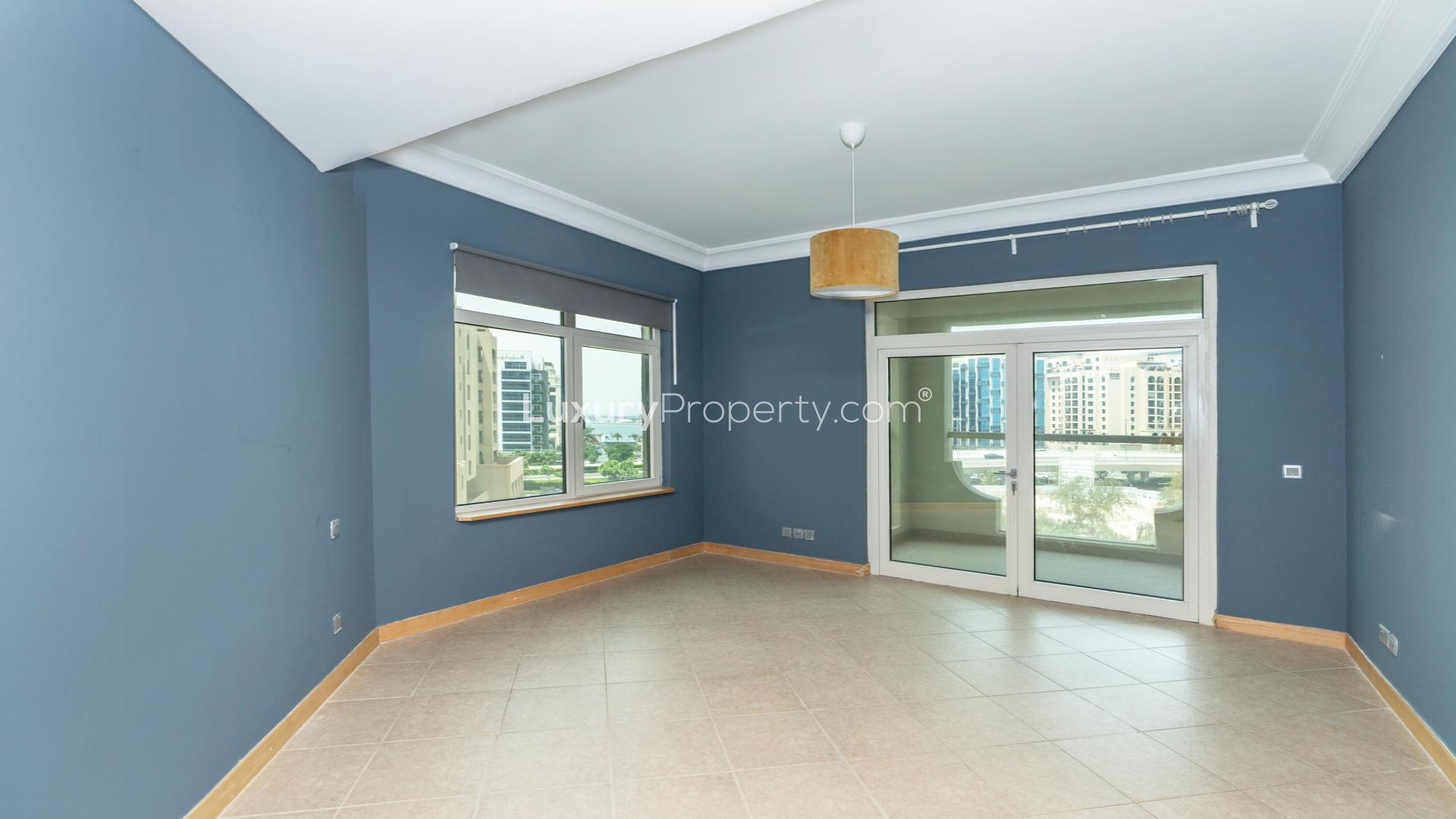"Spacious kitchen in Al Tamr apartment, Palm Jumeirah, with modern cabinets and granite countertops.",Empty living room in Al Tamr Apartment, Palm Jumeirah, with balcony view