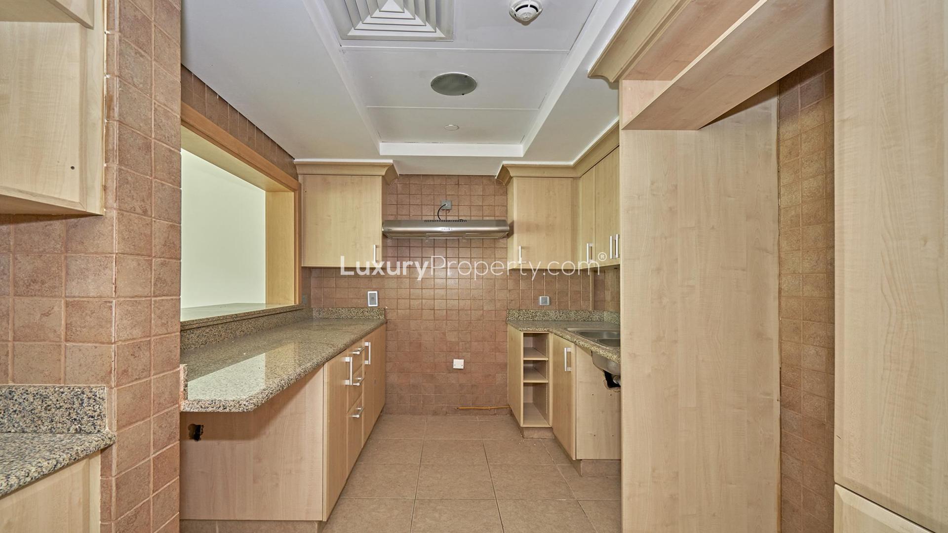 Empty living room in Palm Jumeirah Shoreline Apartment with large windows and balcony view