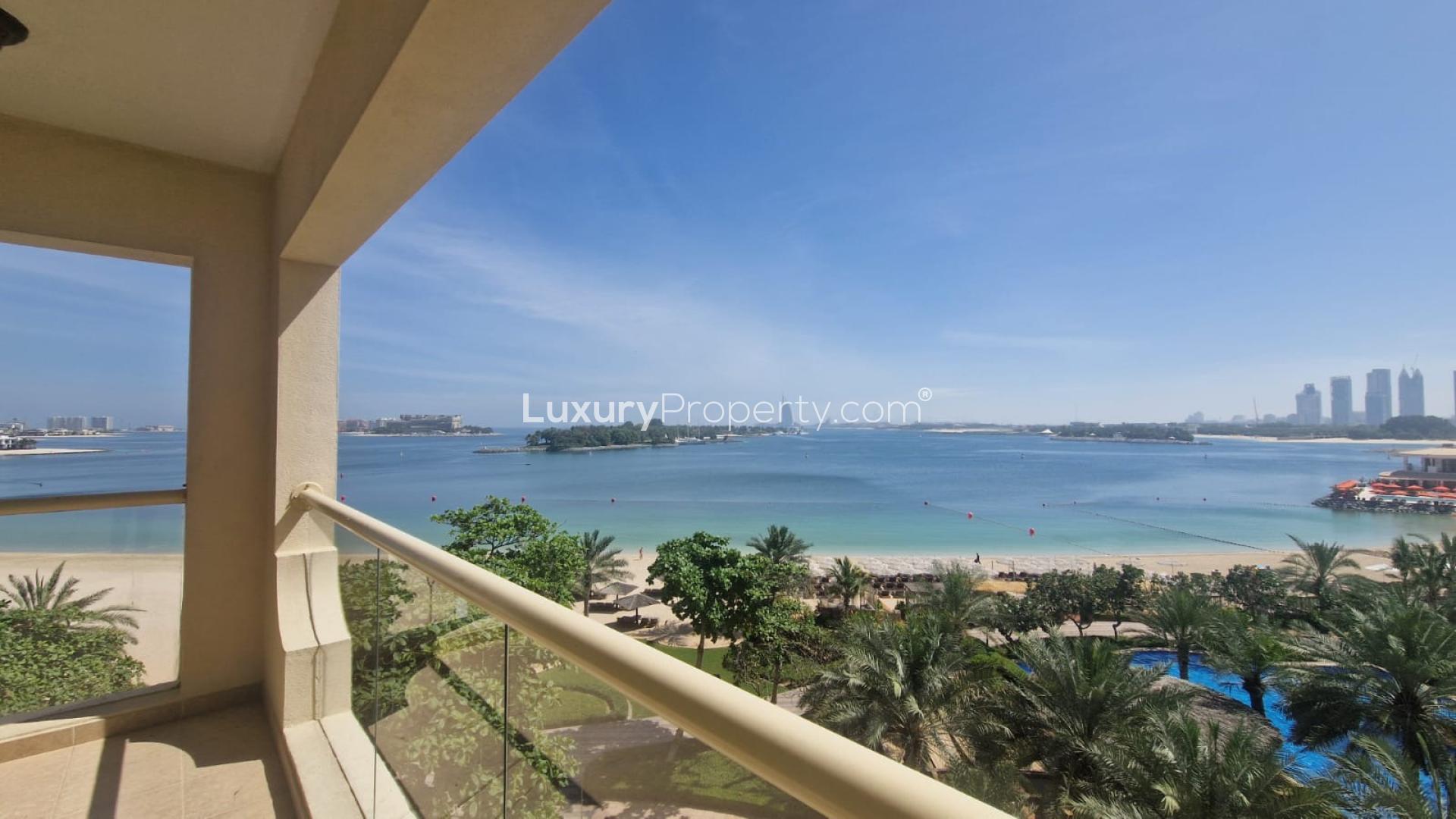 "Beachfront view from Shoreline Apartments, Palm Jumeirah, with lush greenery and sea vista.",Balcony view of Palm Jumeirah shoreline from Shoreline Apartments, LP48822 rental listing