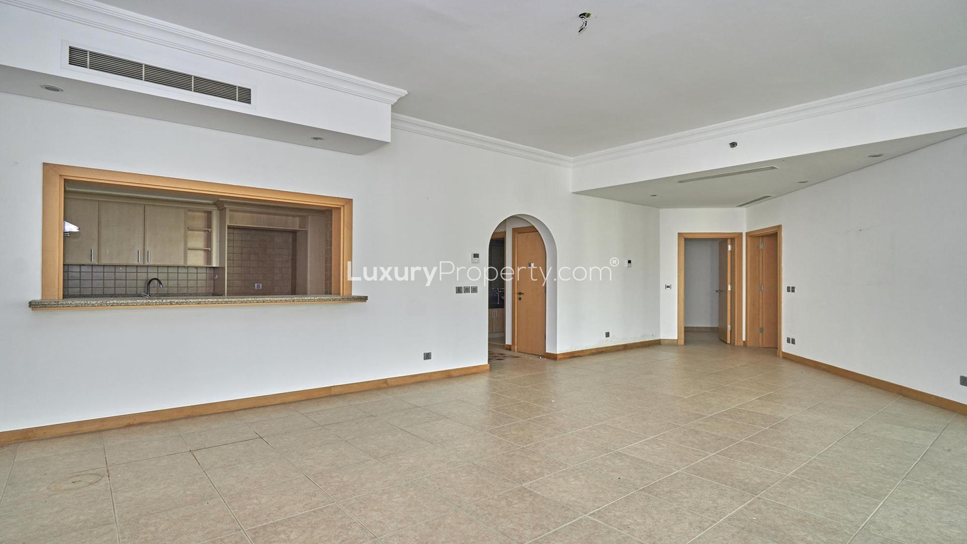 Empty living room in Shoreline Apartments, Palm Jumeirah, with large windows and tiled floor