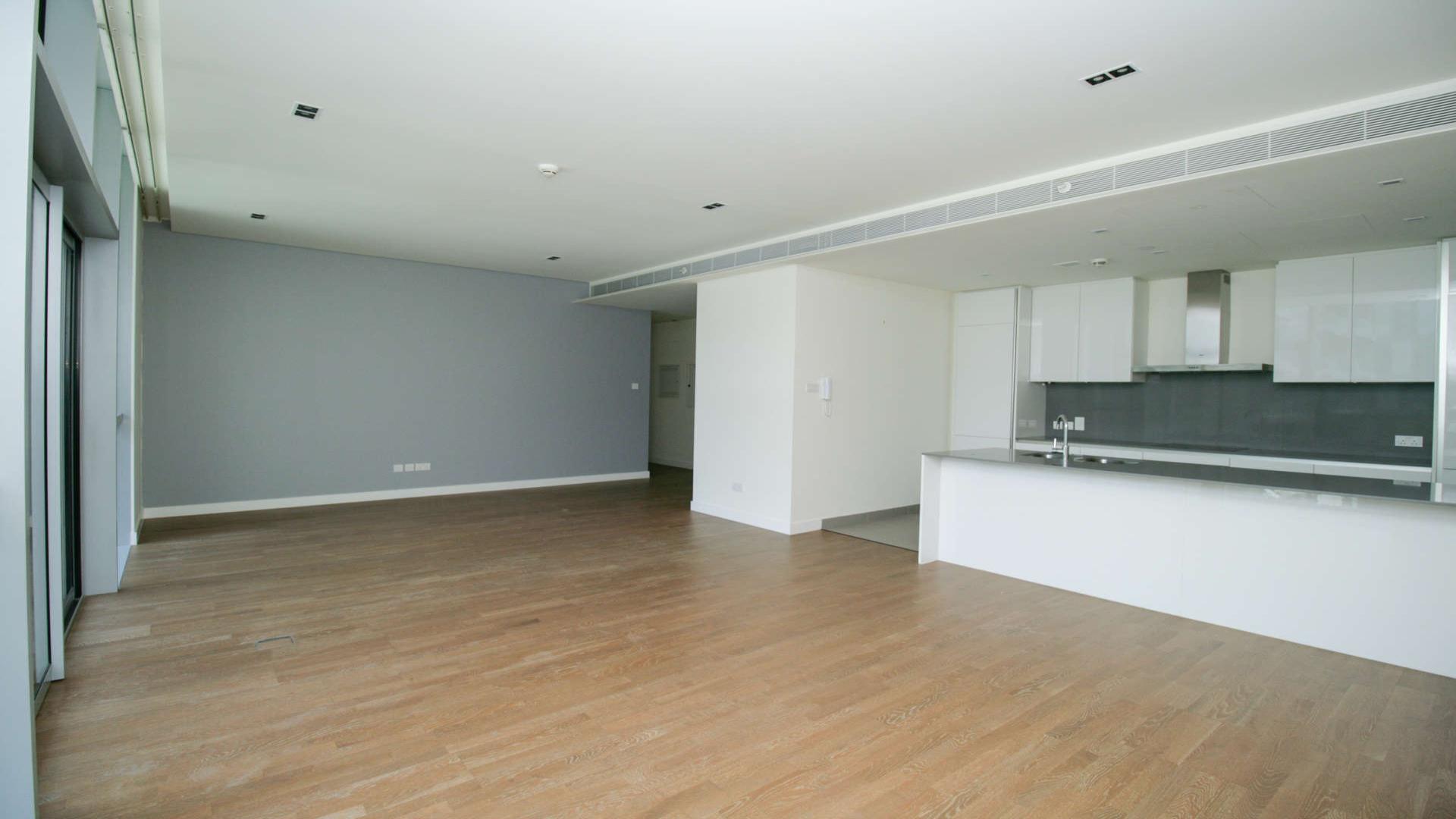 Spacious living room with hardwood floors and large windows in City Walk apartment for rent