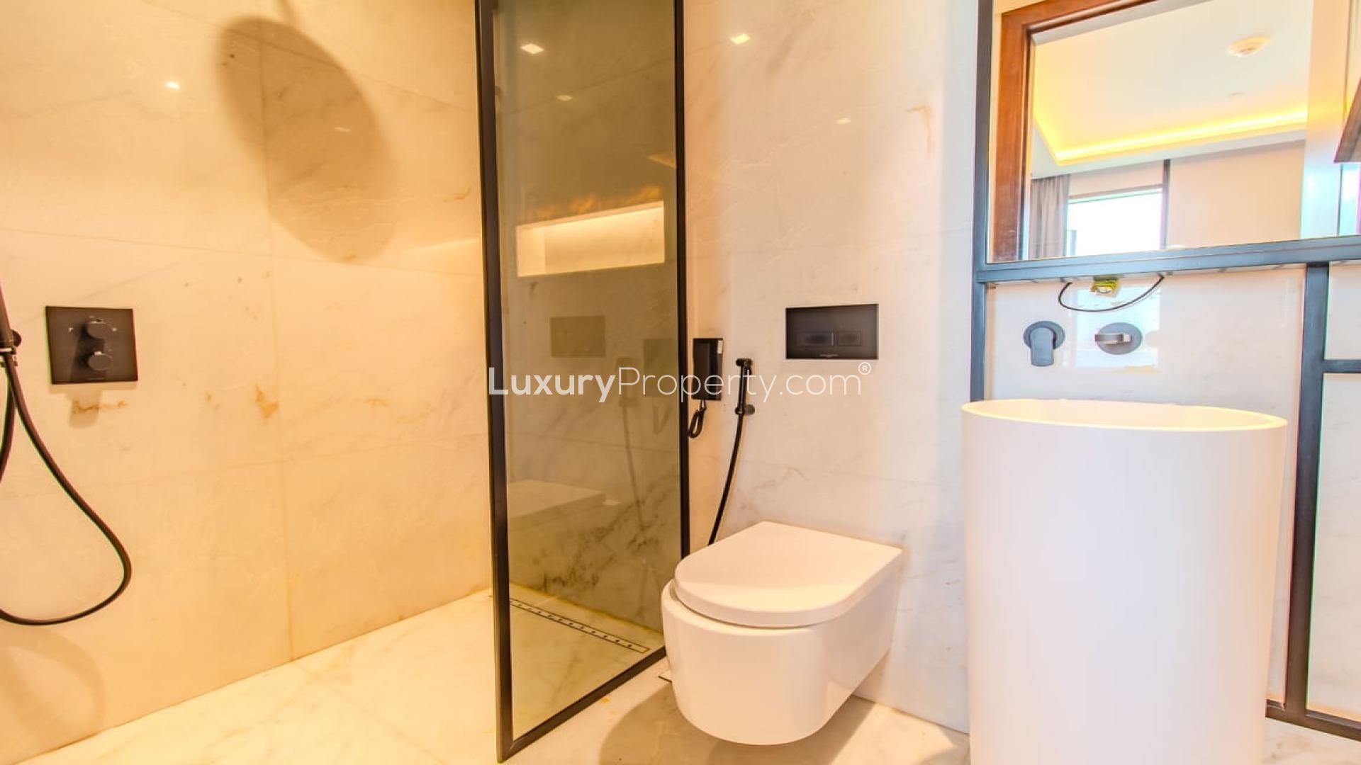 Furnished living room in Bluewaters apartment with modern decor and wall-mounted TV