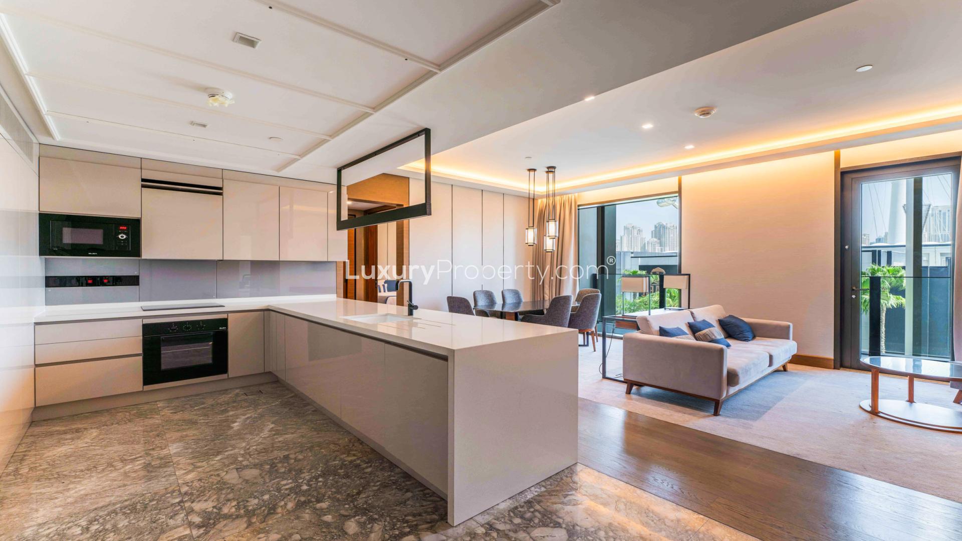 Elegant living room in Bluewaters apartment, modern decor, open kitchen, dining area, cozy ambiance