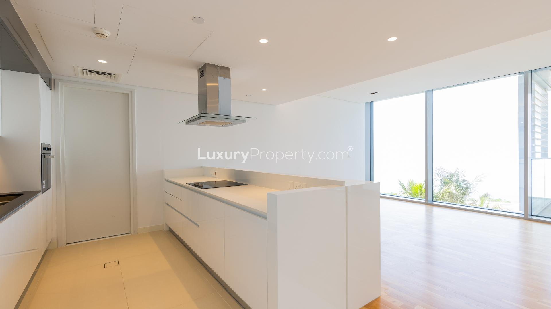 "Balcony view of Bluewaters Residences apartment with sea and pool in the background.",Modern kitchen with sea views in Bluewaters Residences apartment, available for rent