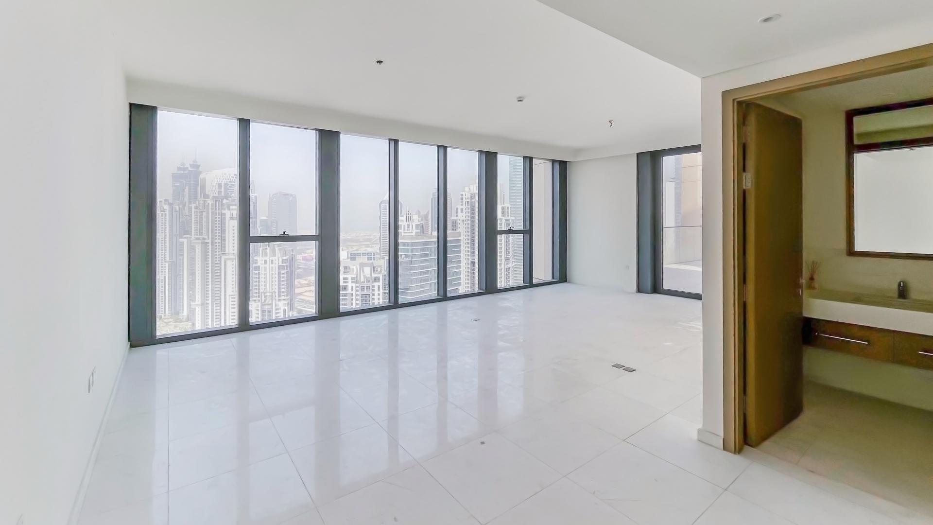 Bright living room with floor-to-ceiling windows in Downtown Dubai duplex apartment for rent