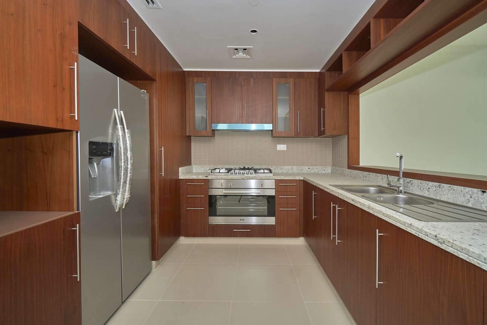 Modern kitchen with wooden cabinets and appliances in Boulevard Point apartment, Downtown Dubai