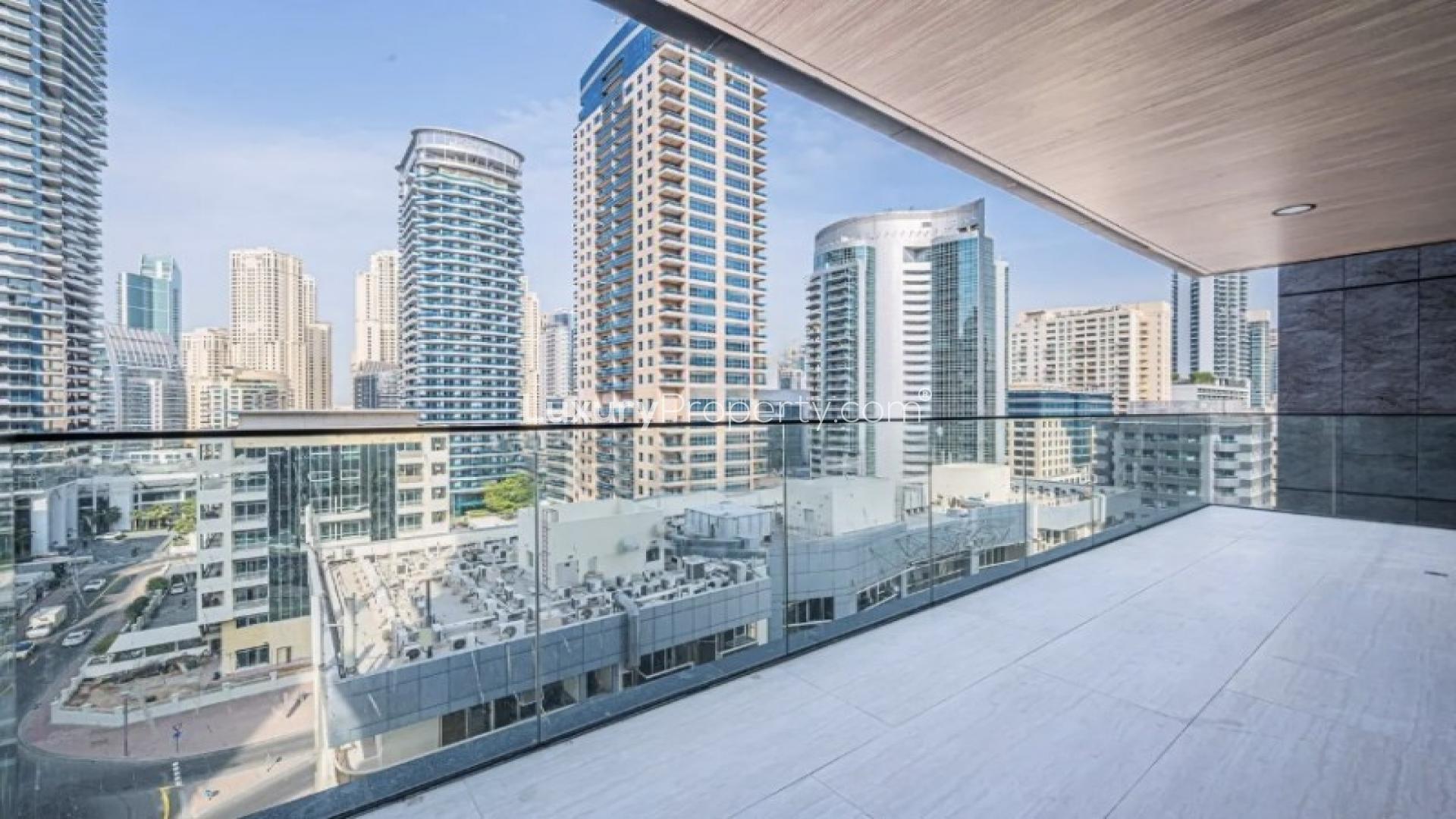 Bright living room with large windows and city view in Marina Living apartment, Dubai Marina