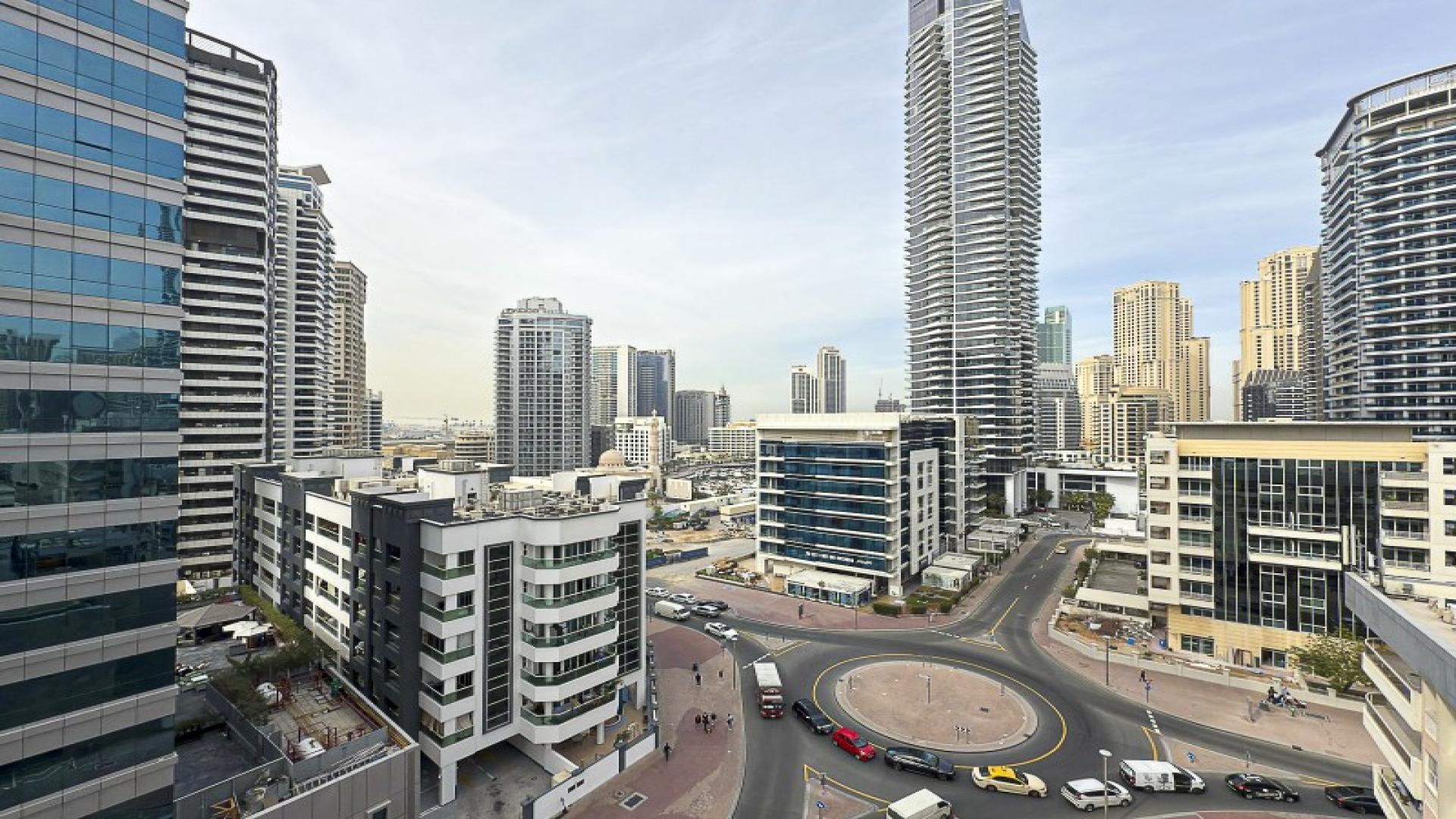 Modern kitchen and living area with city view in Marina Living apartment, Dubai Marina