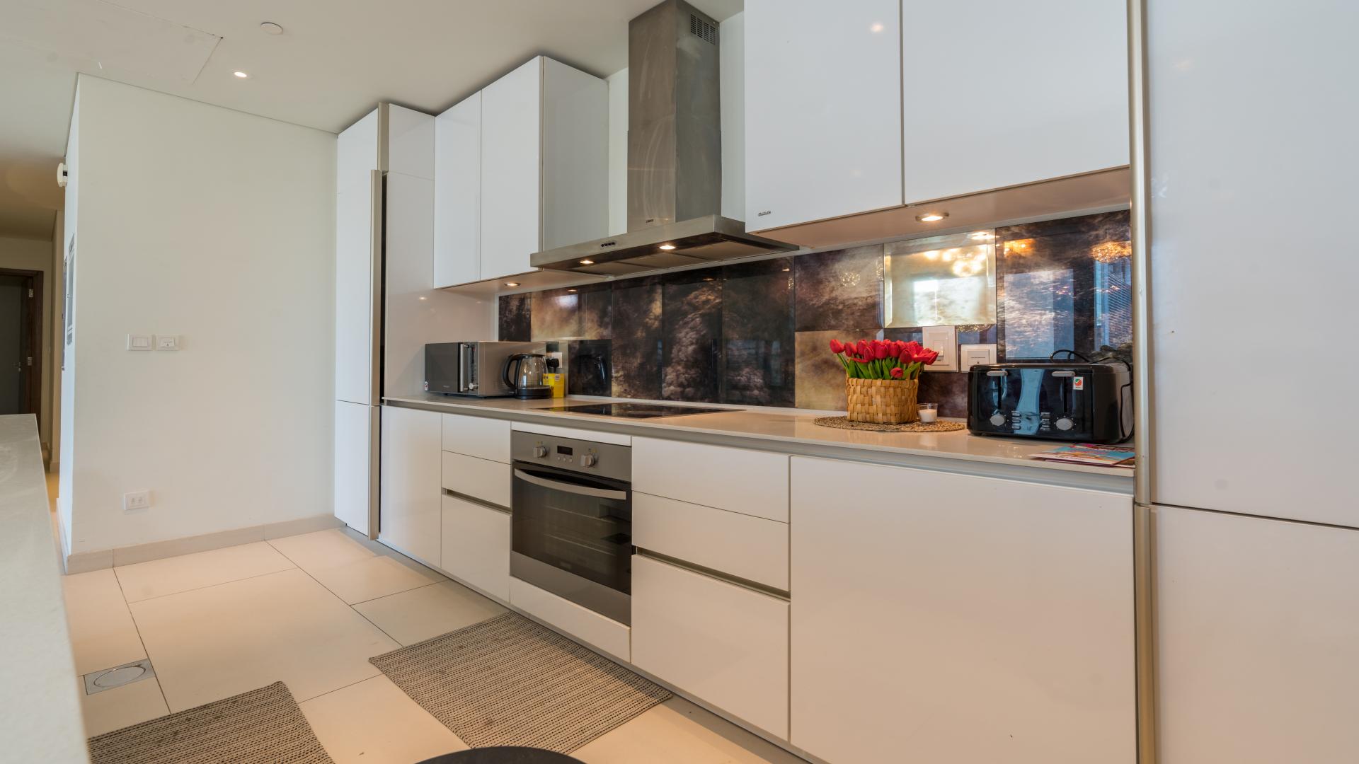 Modern kitchen in City Walk Building 9 apartment, featuring sleek white cabinetry and appliances