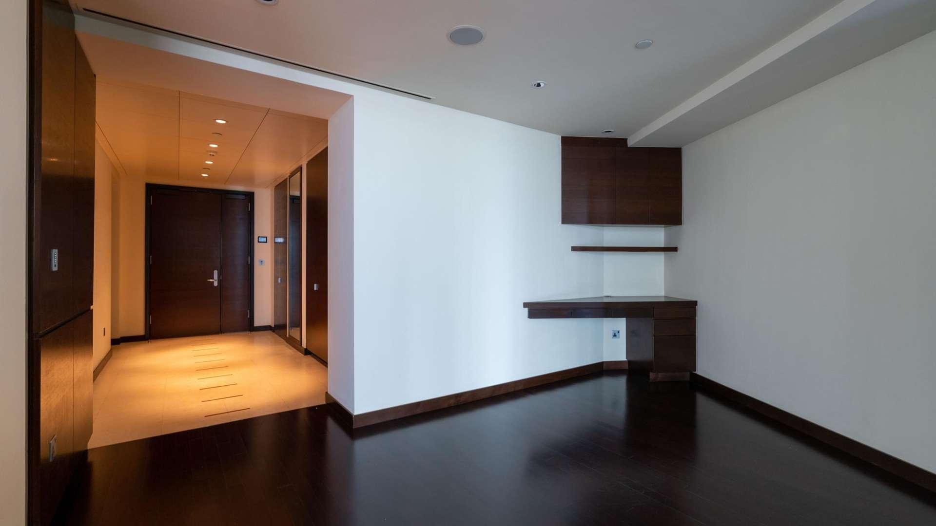 Empty room in spacious Downtown Dubai apartment, dark wood floors, modern design