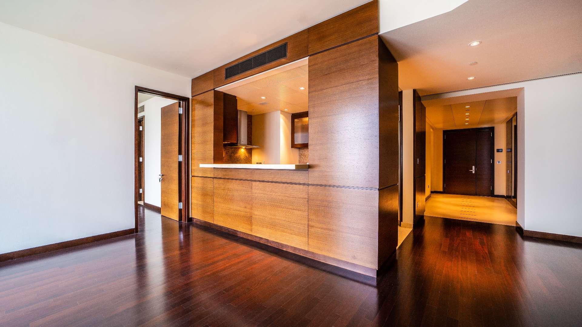 Modern Burj Khalifa apartment interior with wooden floors and open kitchen layout
