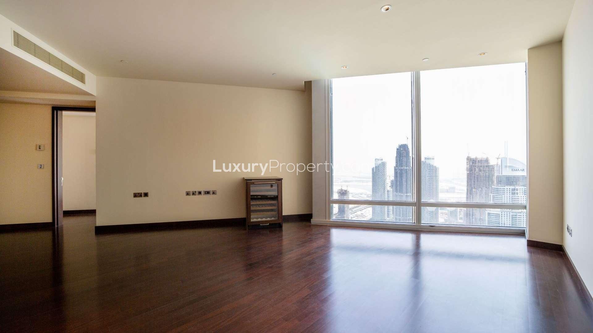 "Stunning view of Dubai Fountain from Burj Khalifa apartment, Downtown Dubai, for rent.",Empty apartment with Dubai Fountain views, Burj Khalifa, Downtown Dubai, dark wood flooring