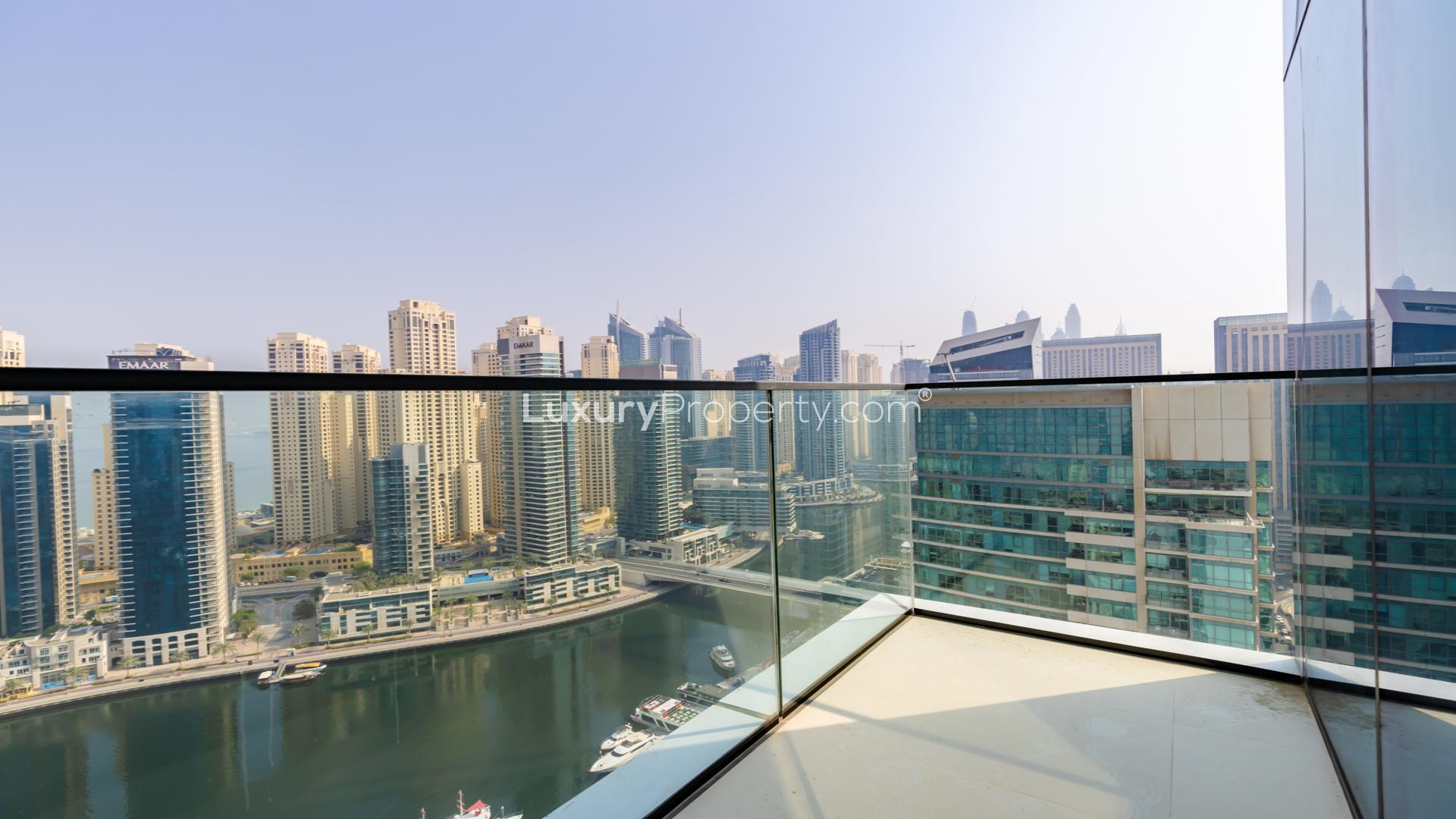 Empty living room with large windows and stunning Dubai Marina skyline view at Vida Residence