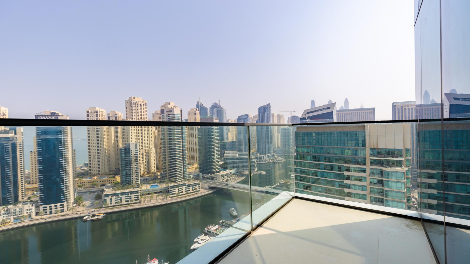 Empty living room with large windows and stunning Dubai Marina skyline view at Vida Residence