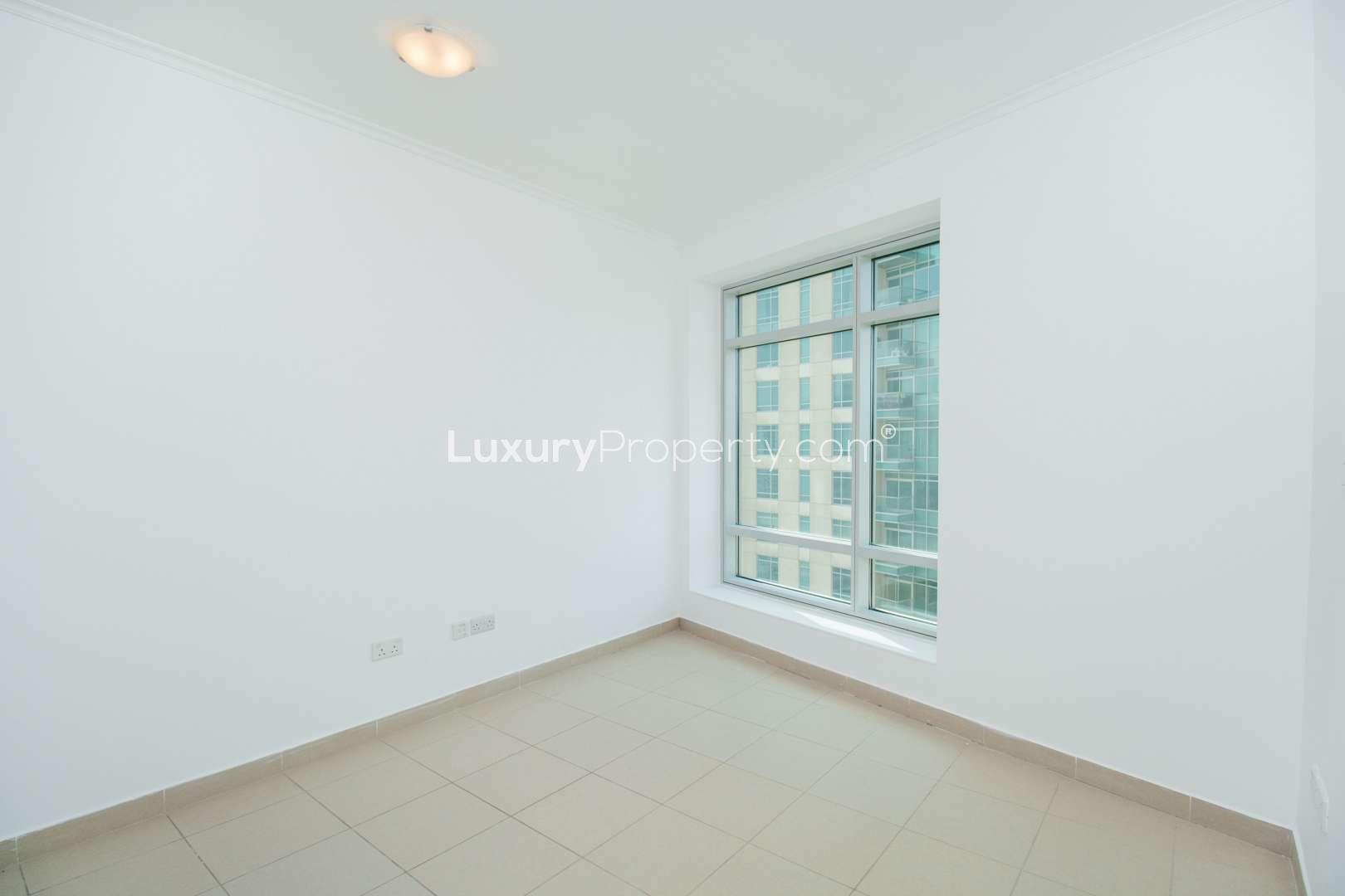 Empty living room with open kitchen in Downtown Dubai apartment for rent