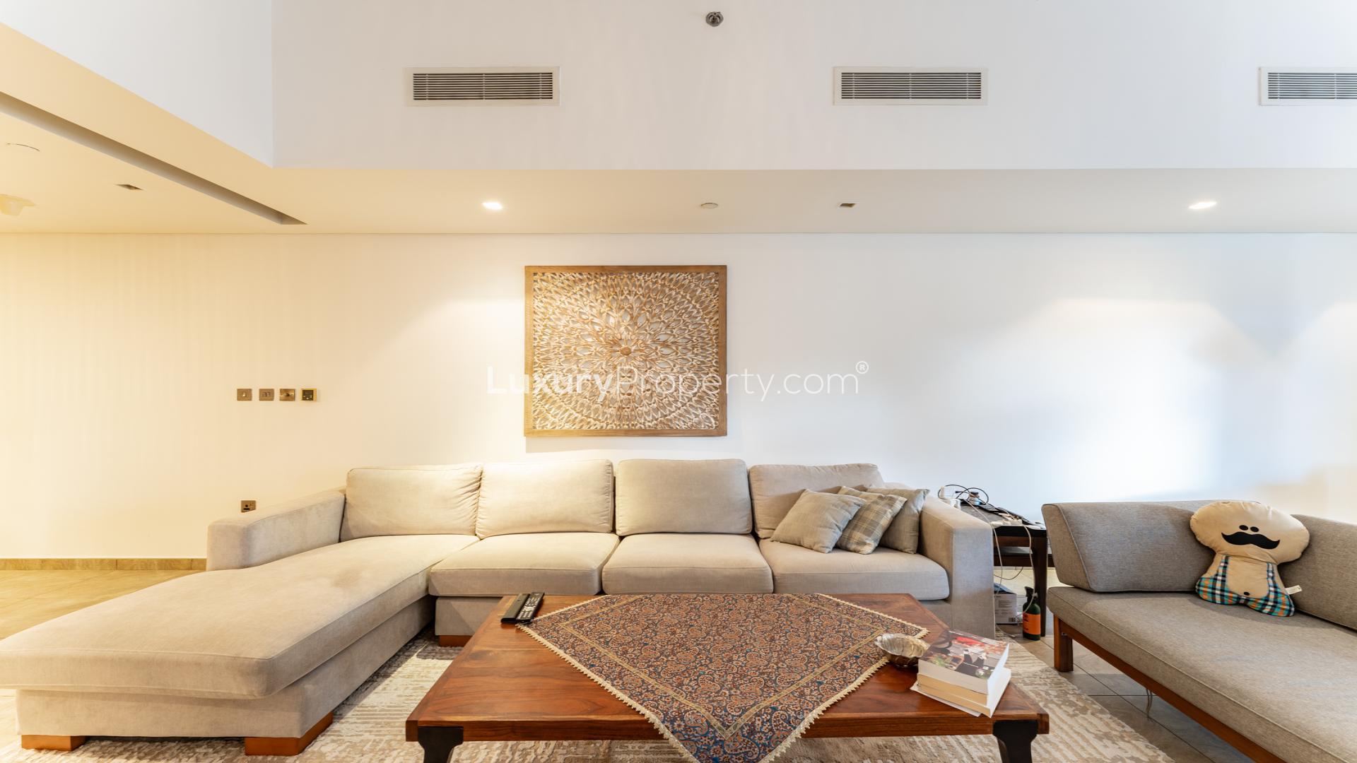 Modern living room in Palm Jumeirah apartment, featuring a cozy beige sectional sofa