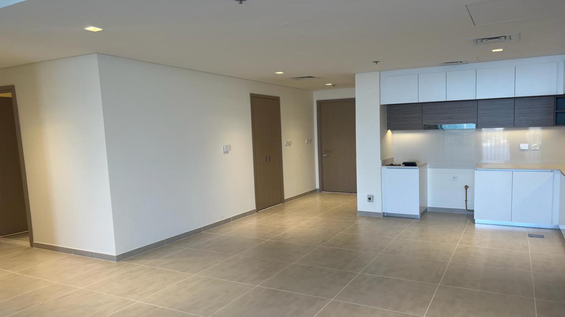 "Modern kitchen and living space in Creek Edge apartment, Dubai Creek Harbour, for rent.",Empty living area in Creek Edge apartment, tiled floors, built-in wardrobe, Dubai Creek Harbour