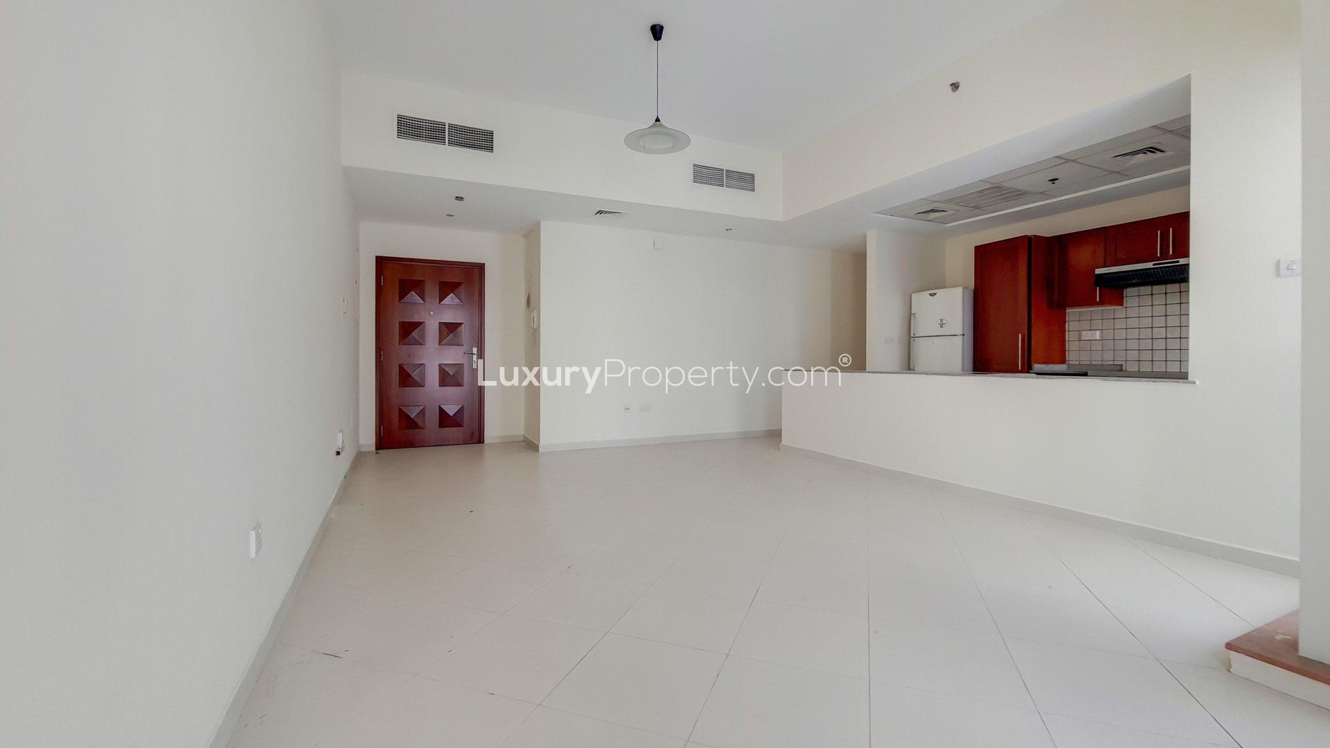 Empty living room in Cascades Tower apartment, Dubai Marina, with large windows and tiled flooring