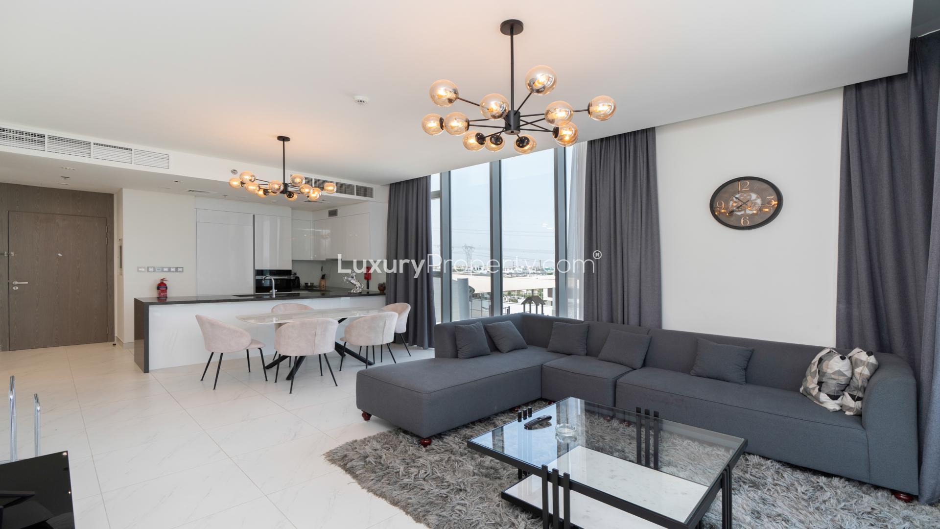 Fully furnished living room with modern decor and city views in District One apartment