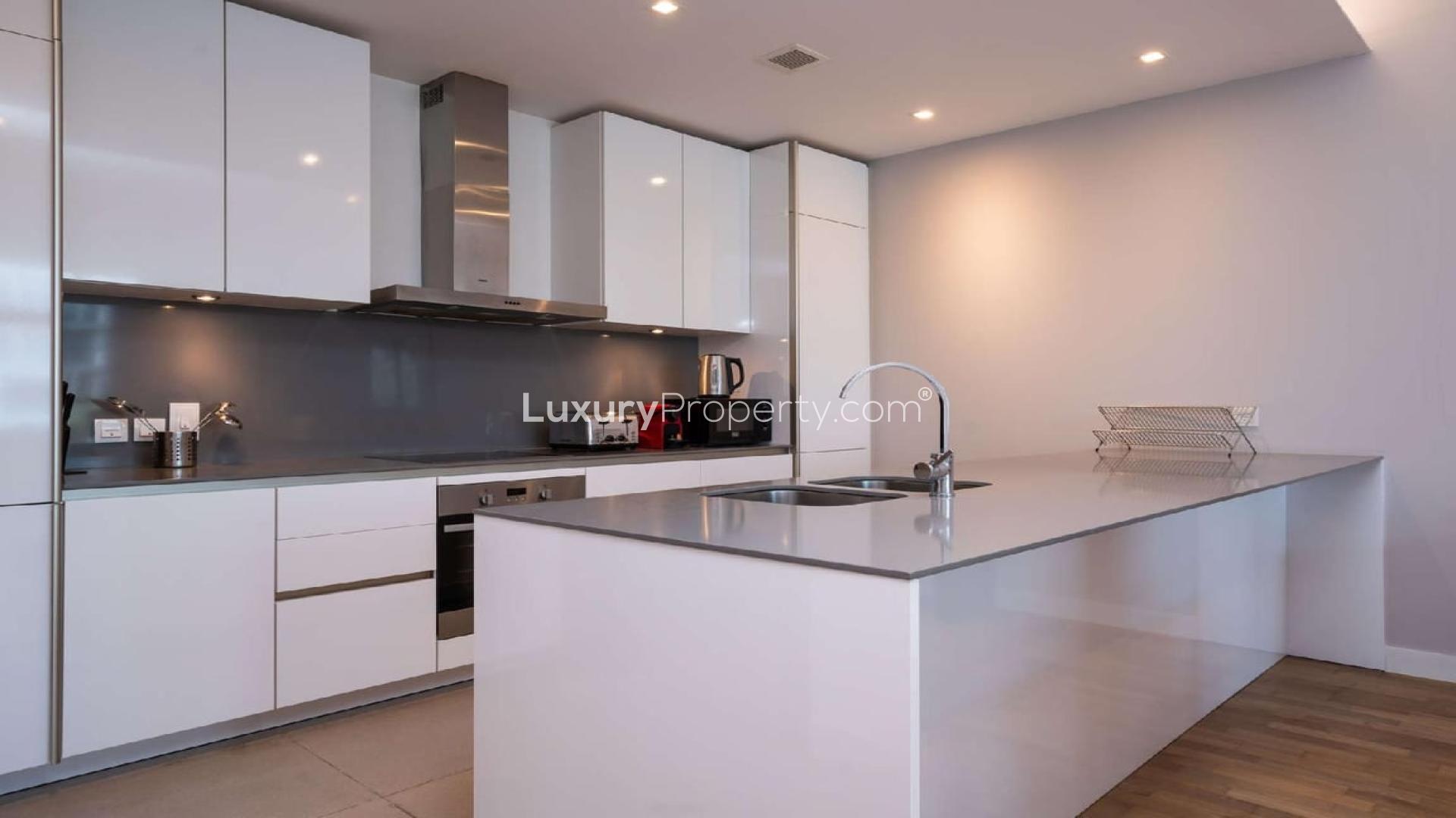 Modern kitchen in City Walk apartment, featuring sleek countertops and integrated appliances