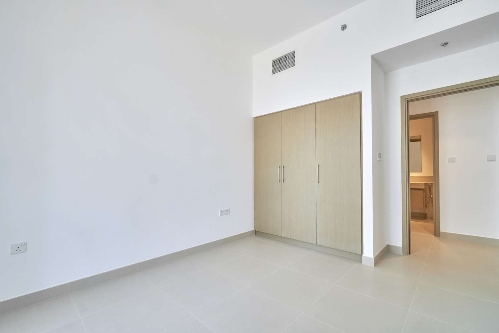 Empty bedroom with built-in wardrobe in Creek Horizon apartment, Dubai Creek Harbour