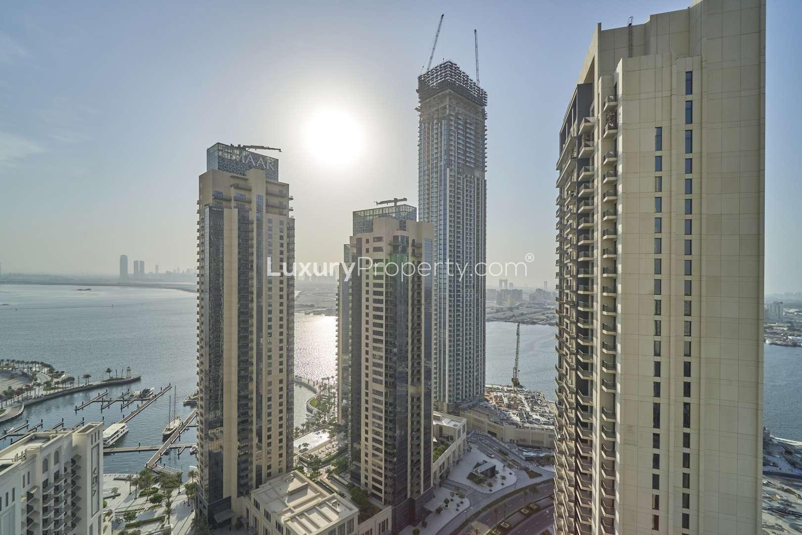 "Stunning view from Creek Horizon apartment overlooking marina and Dubai skyline at sunset.",Luxury apartment view of Dubai Creek Harbour skyline and marina, Creek Horizon, Dubai