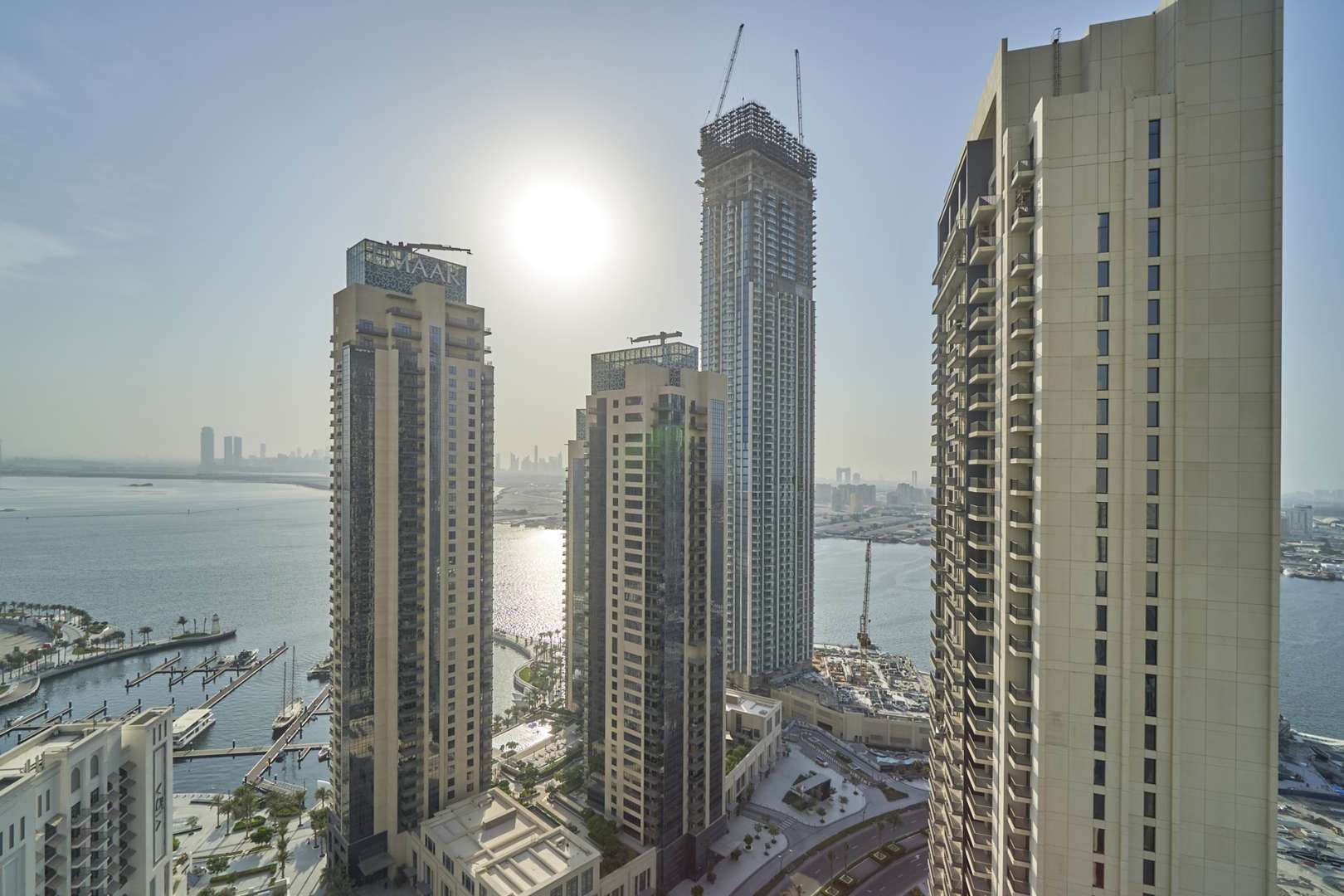 "Stunning view from Creek Horizon apartment overlooking marina and Dubai skyline at sunset.",Luxury apartment view of Dubai Creek Harbour skyline and marina, Creek Horizon, Dubai