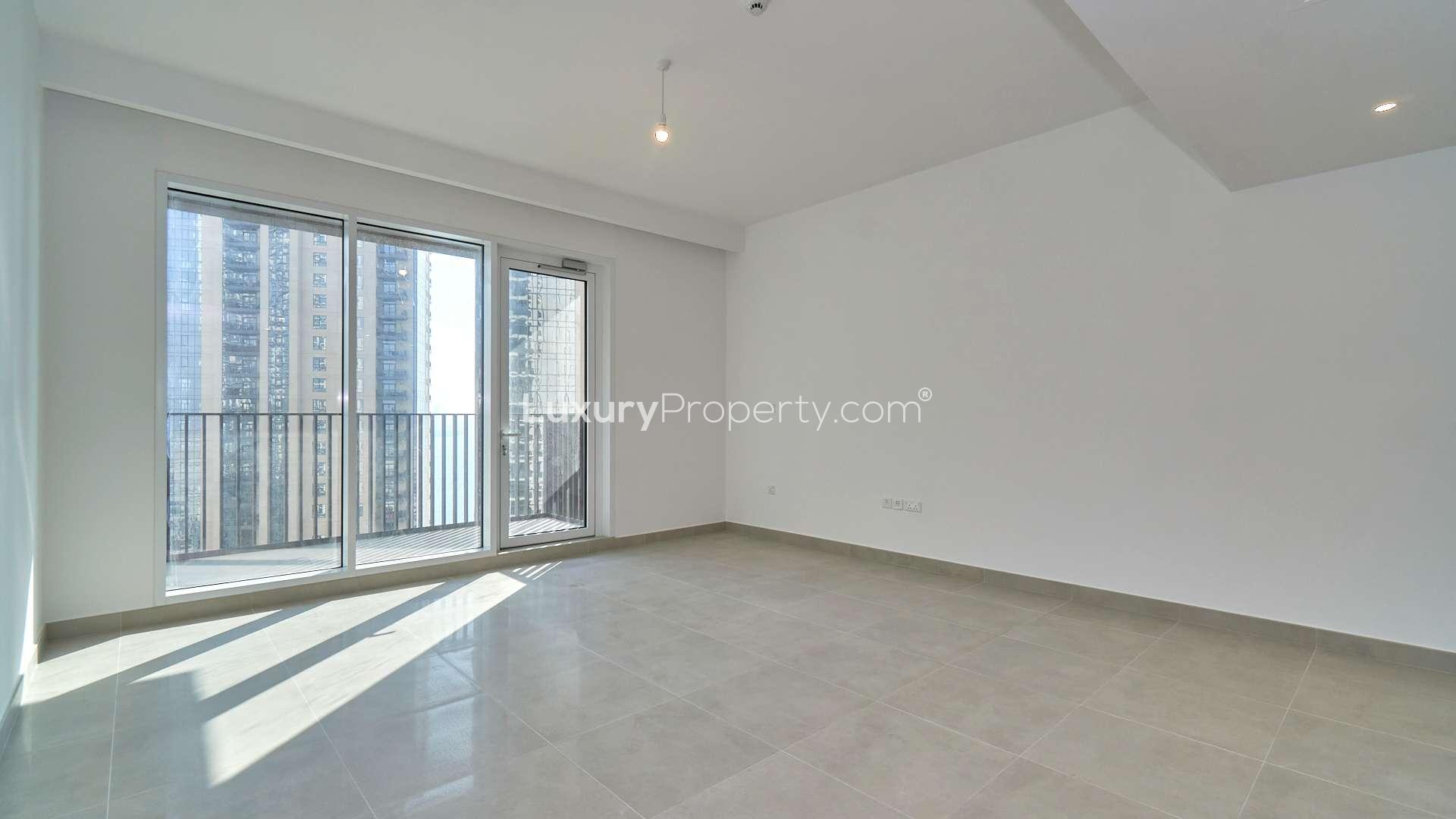 High-floor empty living room in Creek Horizon apartment, Dubai Creek Harbour, with balcony view