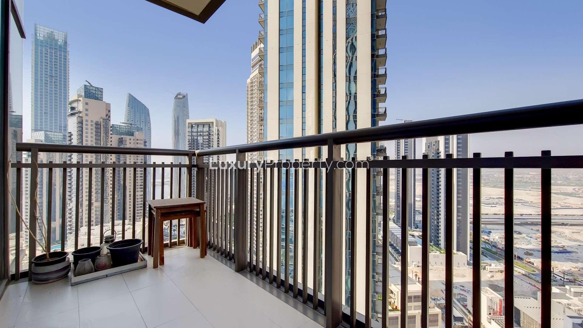 Tall residential towers in Creekside 18, Dubai Creek Harbour, with palm trees and clear sky