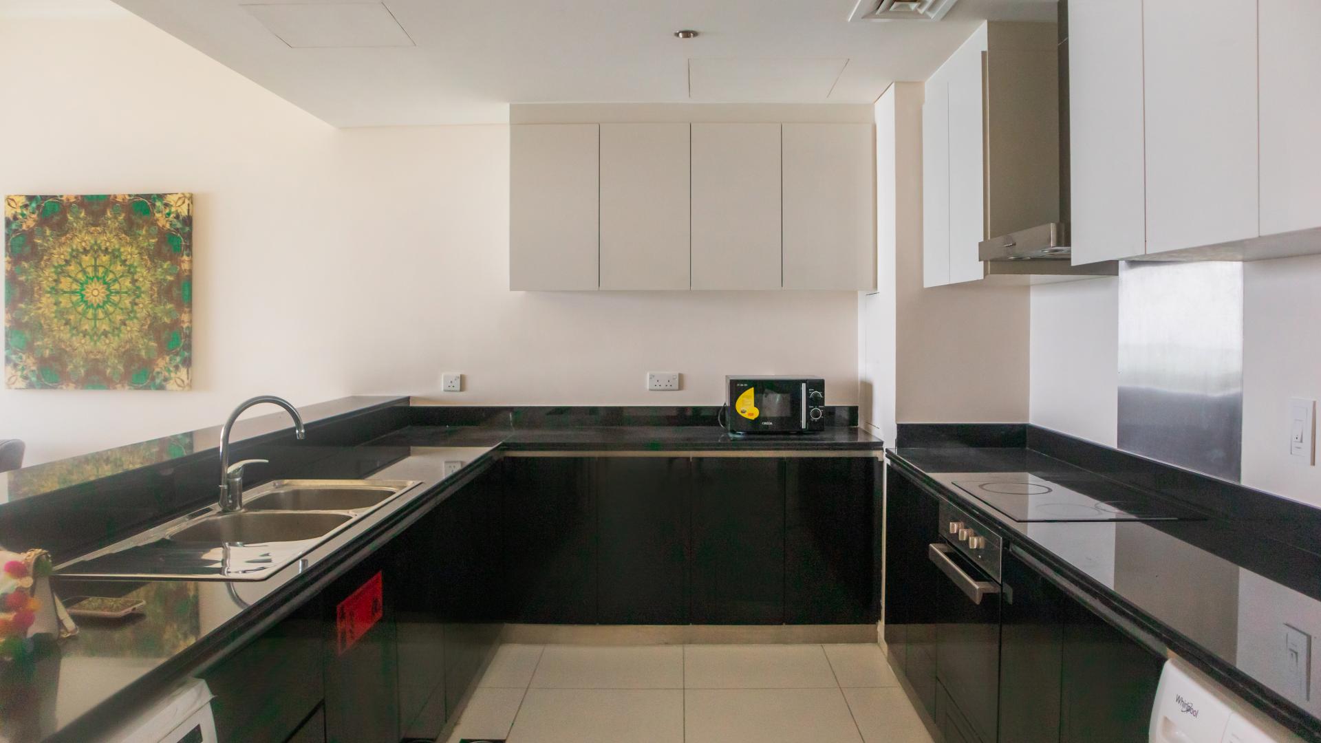 "Stunning sea view from fully furnished apartment in Damac Heights, Dubai Marina, for rent.",Modern kitchen in fully furnished Dubai Marina apartment, Damac Heights, with sleek black countertops