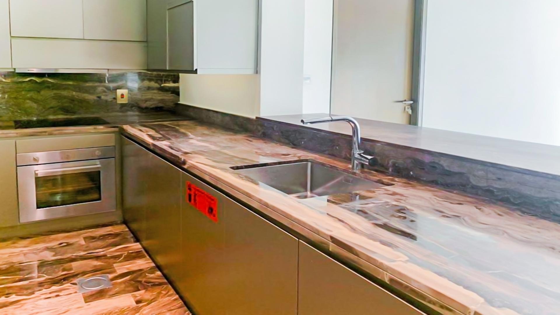 Luxury kitchen in Damac Heights apartment, featuring sleek countertops and modern appliances