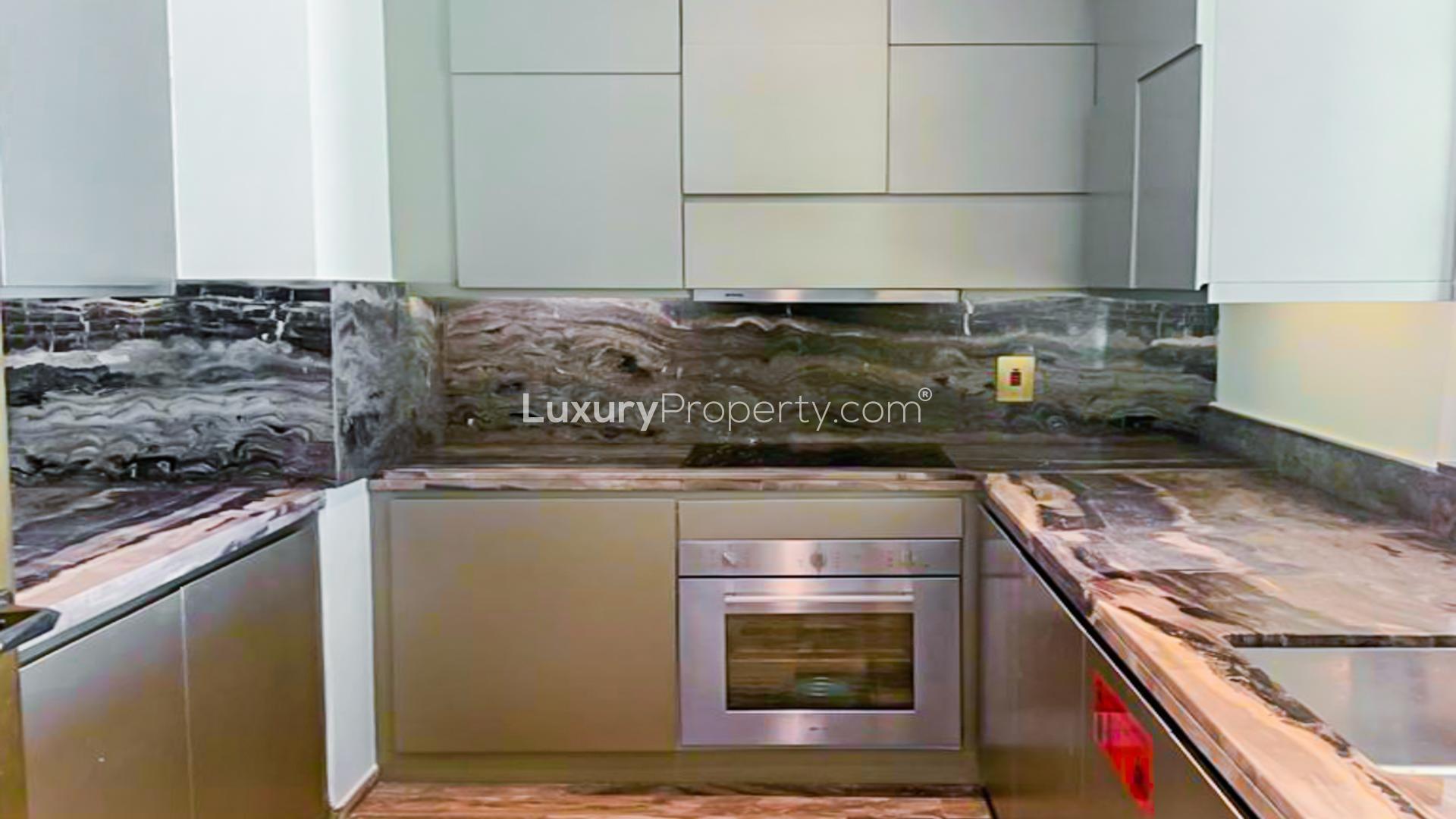 "Modern kitchen with marble countertops in luxury Fendi apartment, Damac Heights, Dubai Marina.",Empty room with dark wooden floor and sea view balcony in Damac Heights, Dubai Marina