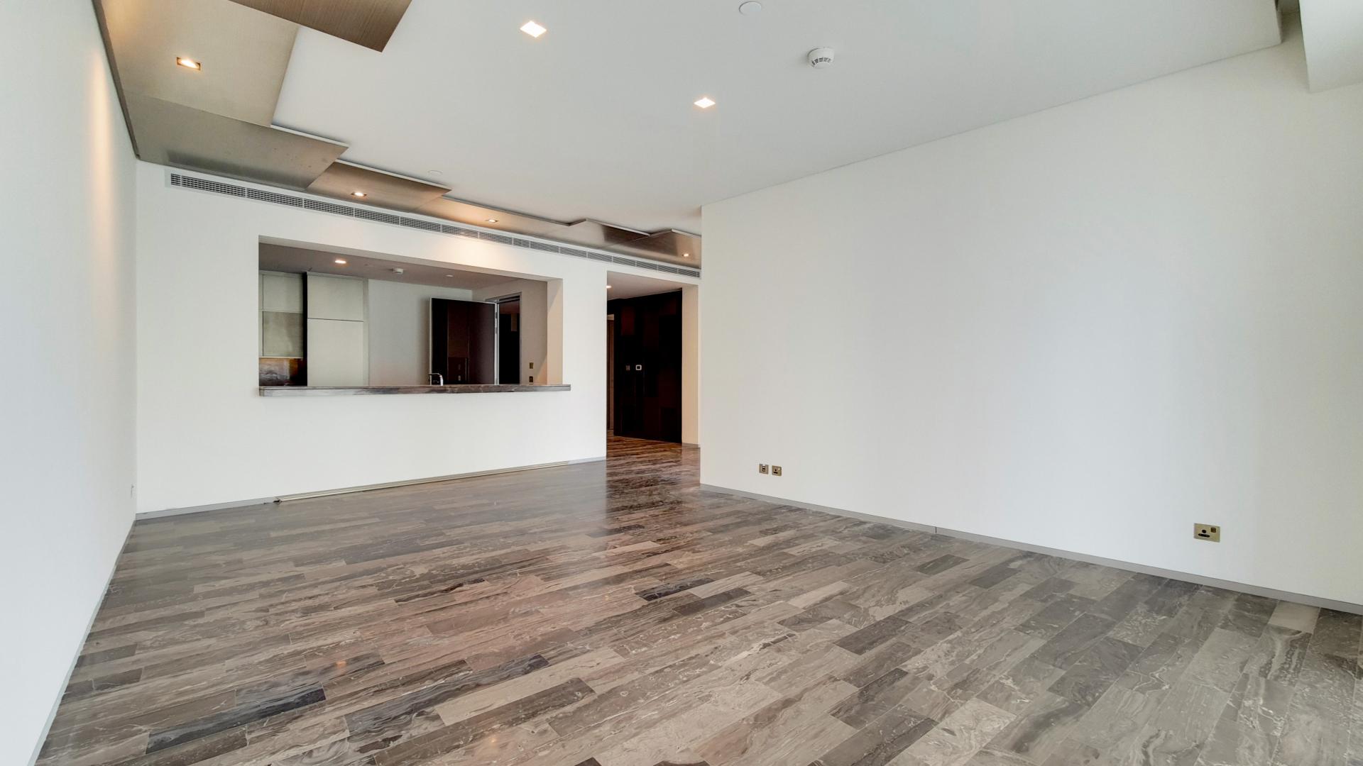 Empty living area in Damac Heights apartment with modern flooring and open kitchen