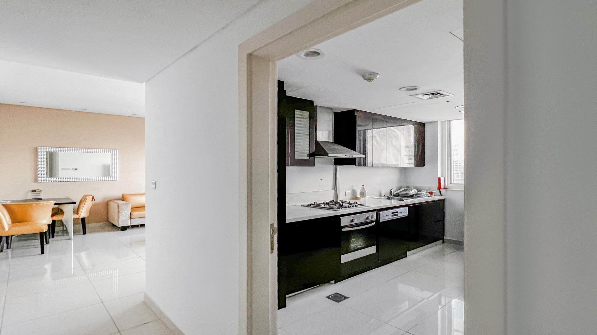 Modern living room in furnished Business Bay apartment, featuring sleek decor and TV unit