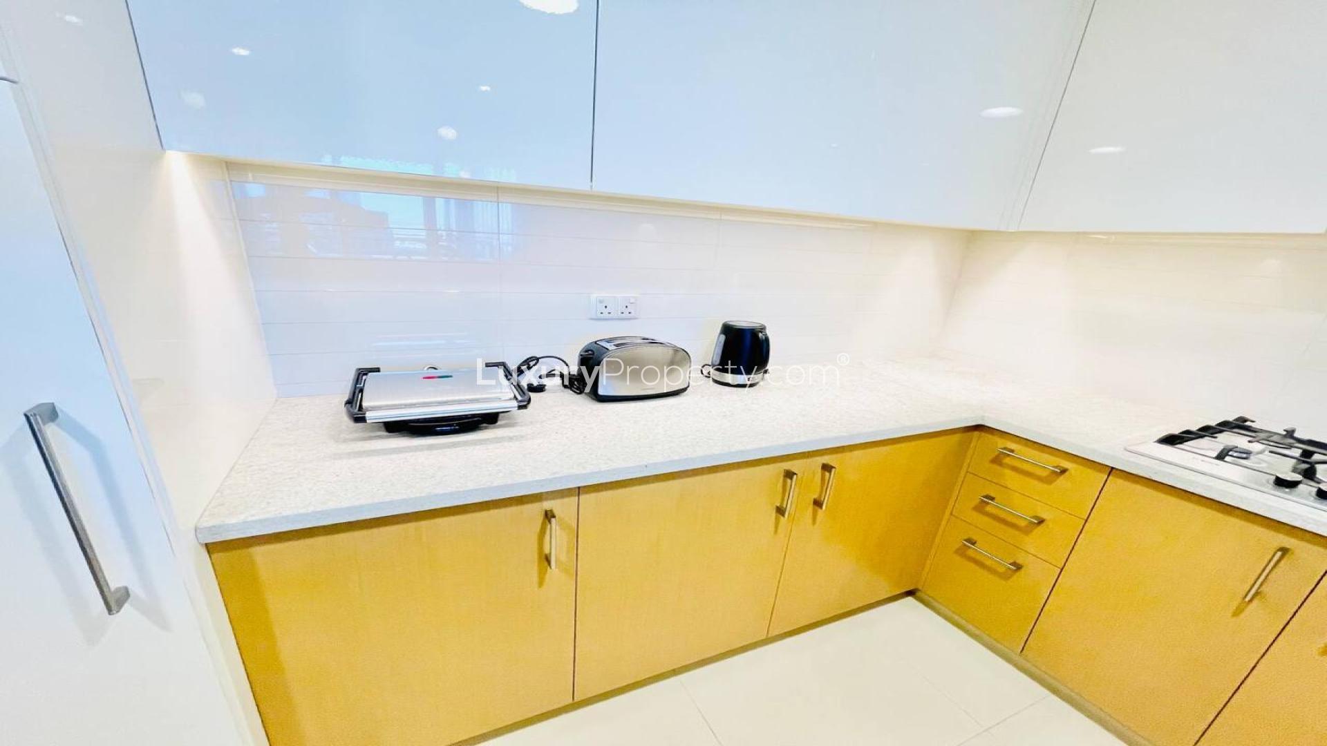 Furnished Downtown Dubai apartment living room with modern decor and wall-mounted TV