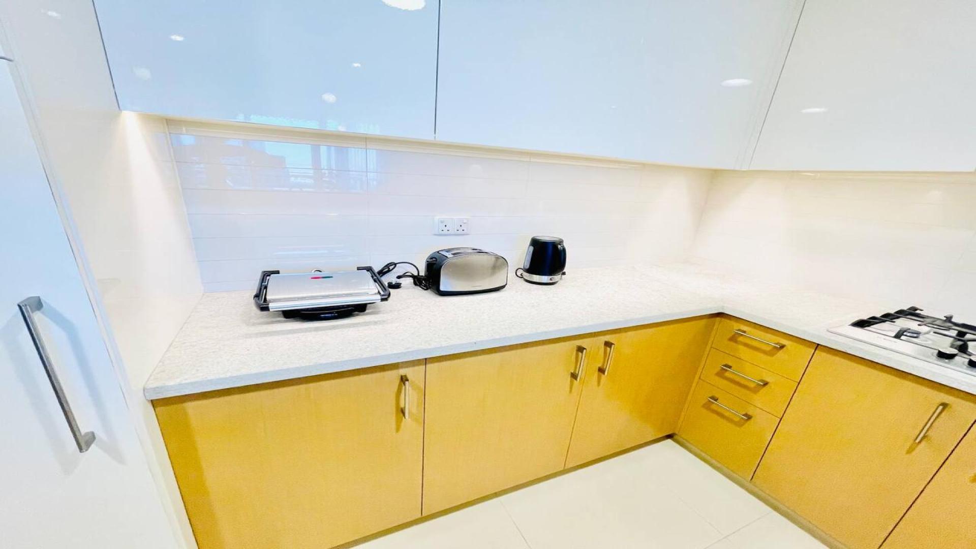 Furnished Downtown Dubai apartment living room with modern decor and wall-mounted TV