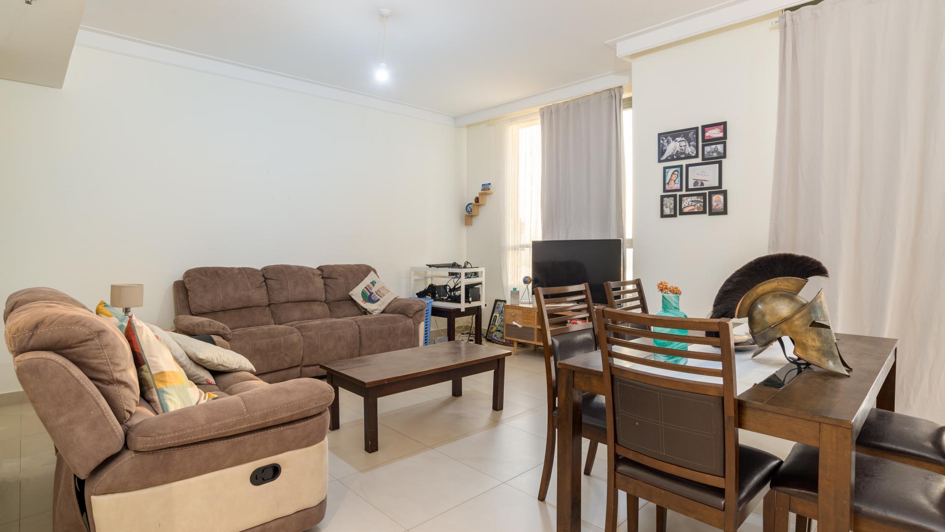 Contemporary apartment living room with desk, chair, and natural light in Dubai Creek